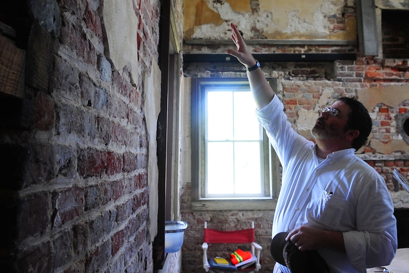 Christopher McDaid, 733rd Civil Engineer division cultural resources manager, examines the various renovations in brickwork to the Matthew Jones House at Fort Eustis, Va., July 17, 2012. The home, estimated to have been built in 1700, is now an architectural study museum. (U.S. Air Force photo by Staff Sgt. Ashley Hawkins/Released)