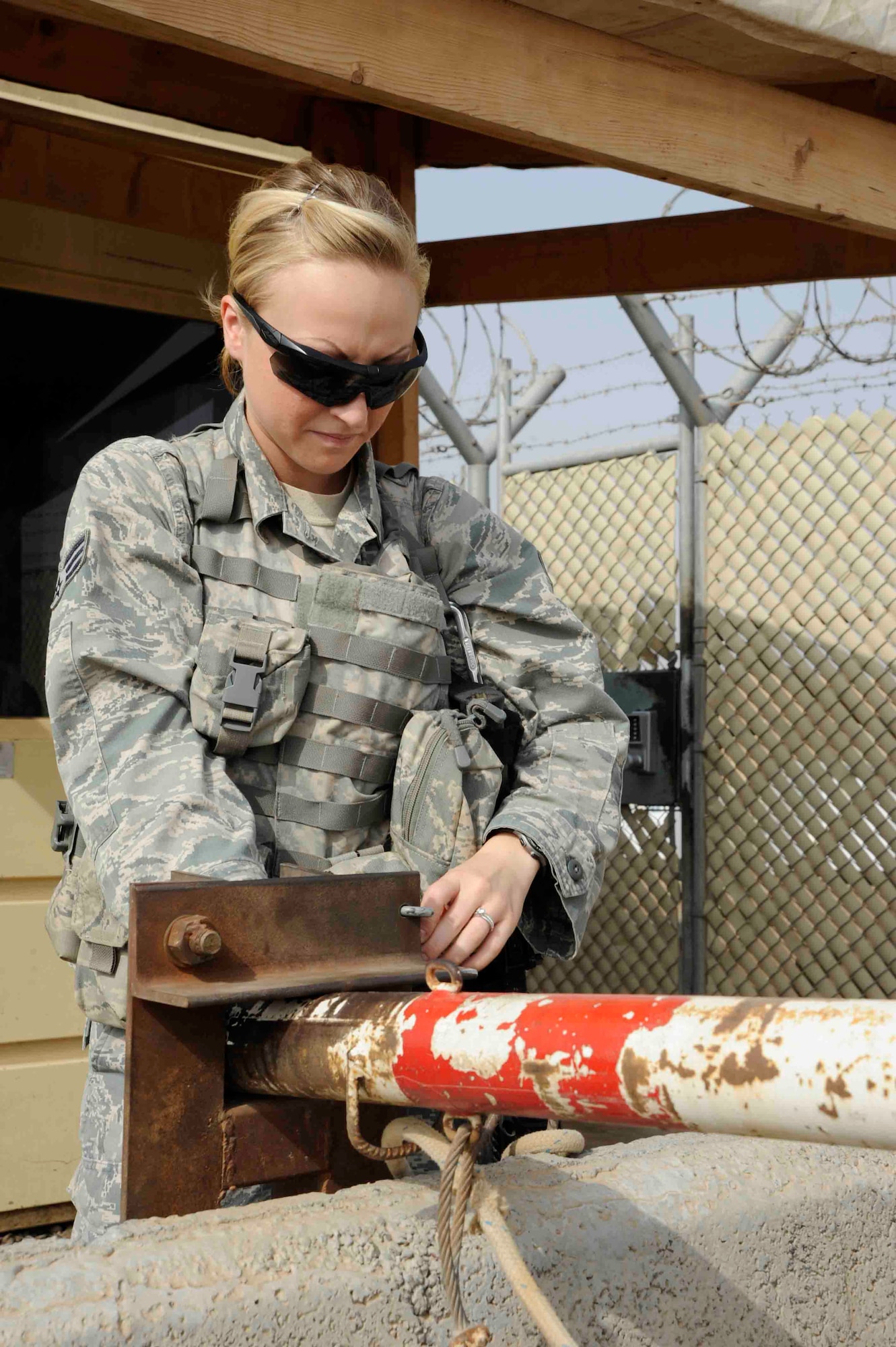 Security Forces member Senior Airman Chelsea Snedden, 726th Expeditionary Air Base Squadron, locks down a vehicle gate on Camp Lemonnier July 17, 2012. Security personnel from different branches integrated July 1 to enhance camp security and help support the mission in the Horn of Africa.  (U.S. Air Force photo by Staff Sgt. Christopher Ruano)