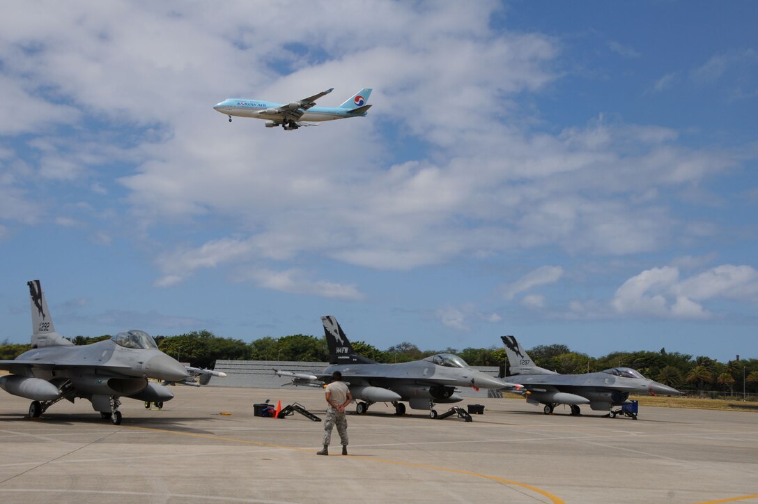 A crew chief from the 144th Fighter Wing stands alert until the F-16 Fighter jet has clearance to take off during RIMPAC 2012. The 2012 Rim of the Pacific exercise is the twenty-third maneuver in a history of bi-annual drills that dates back four decades. The purpose of the exercise is to bring together nations to observe, train and exchange information that fosters a cooperative training environment.  (Air National Guard photograph by MSgt. David J. Loeffler)