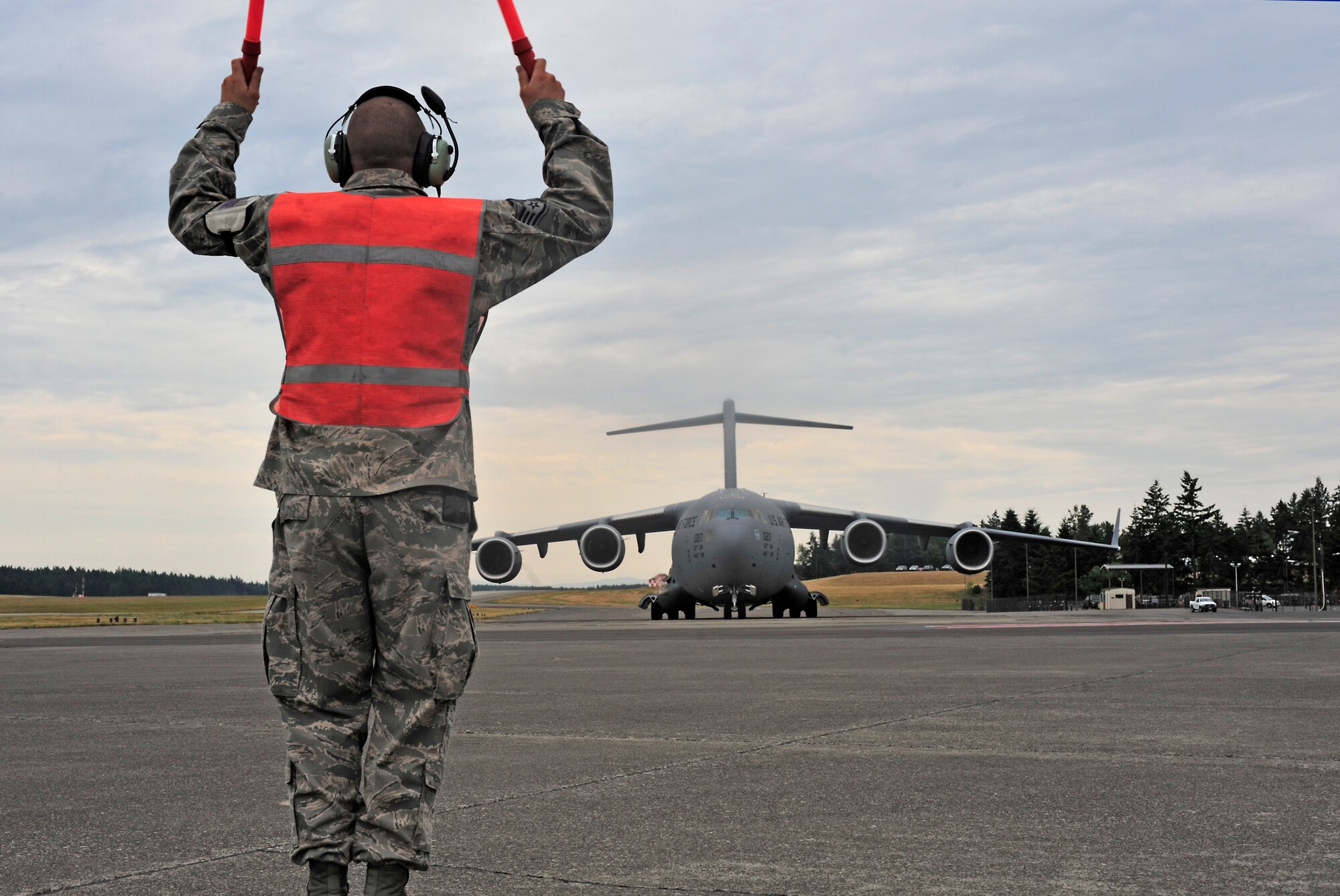 Staff Sgt. Joshua Jaburek, 62nd Aircraft Maintenance Squadron, marshals in McChord Field's newest C-17 Globemaster III aircraft July 17, 2012, at Joint Base Lewis-McChord, Wash. The C-17 was delivered by Gen. William H. Fraser III, U.S. Transportation Command commander. (U.S. Air Force photo/Staff Sgt. Frances Kriss)