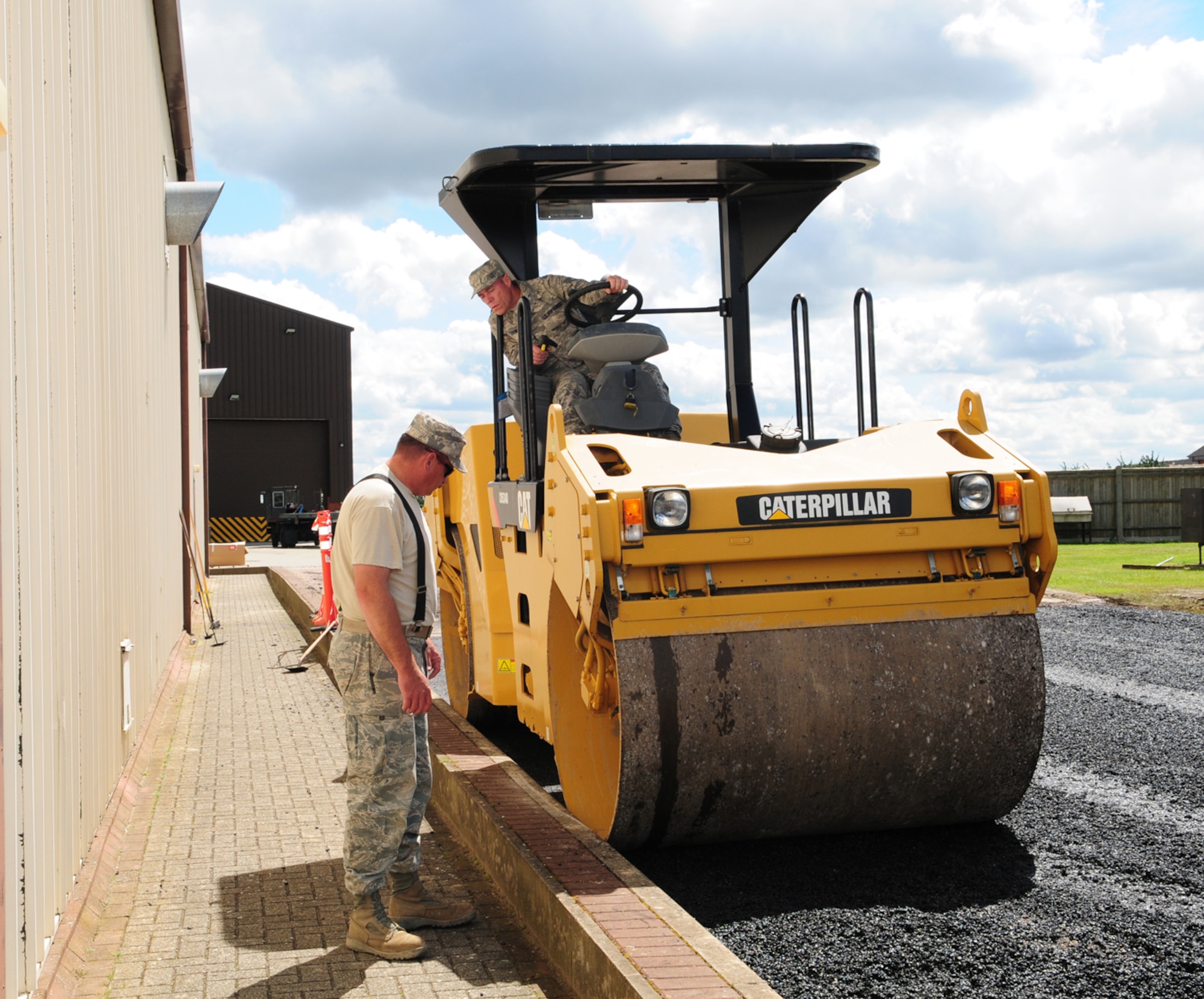 RAF MILDENHALL, England – Staff Sgt. Michael Dowse, 419th Civil Engineer Squadron reservist unit, Hill Air Force Base, Utah, carefully drives a roller along freshly-laid asphalt as Master Sgt. Kelly Wayment, also 419th CES, watches to ensure he flattens the asphalt right up to the edge of the road July 12, 2012. The 419th CES reservists were at RAF Mildenhall for two weeks as part of their annual training. While here, they assisted 100th Civil Engineer Squadron members with projects around base that they ordinarily do not have the manpower to complete. (U.S. Air Force photo/Karen Abeyasekere)