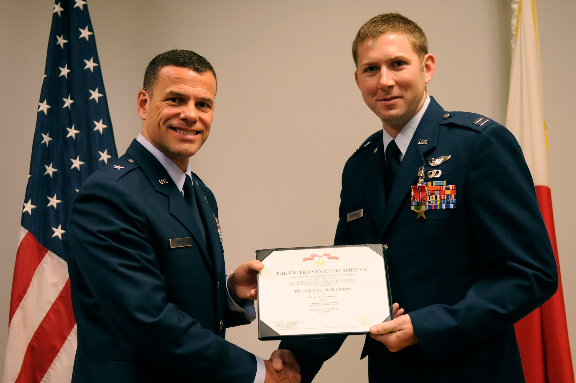 U.S. Air Force Capt. Kevin Geoffroy, 33rd Rescue Squadron HH-60 Pavehawk helicopter pilot, receives a Bronze Star Medal from Brig. Gen. Matthew Molloy, 18th Wing commander, at Kadena Air Base, Japan, July 18, 2012. Geoffroy received the medal for his meritorious achievements as director of operations and flight lead in Afghanistan August 2010 to May 2012. His actions allowed his squadron to maintain nearly 7,500 hours of operations support, resulting in 100 lives saved. (U.S. Air Force photo/Airman Tara A. Williamson)
