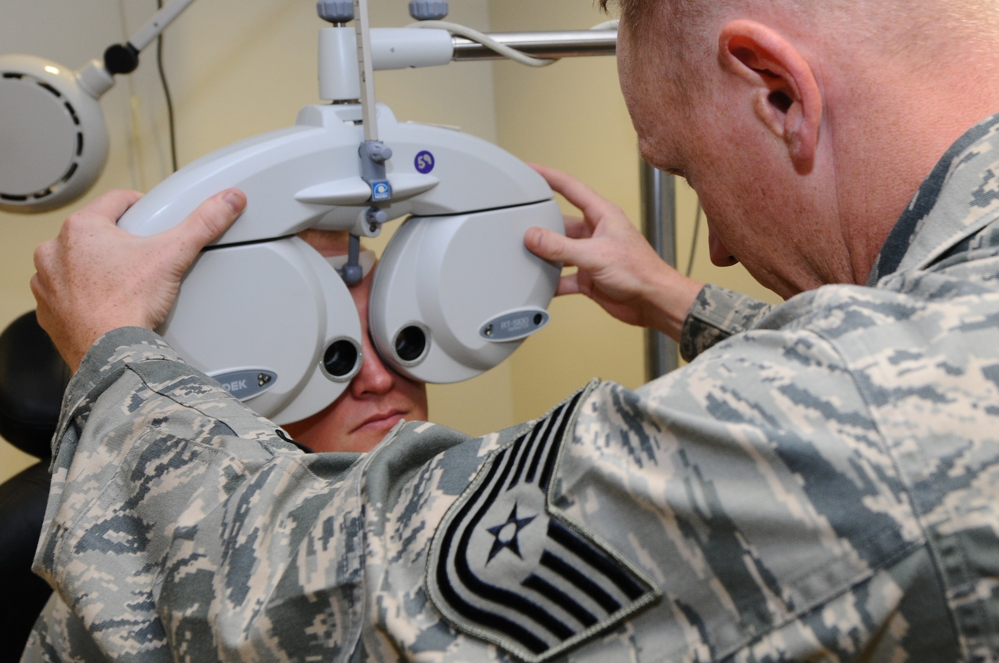 ANDERSEN AIR FORCE BASE, Guam - Tech. Sgt. Joshua Karash, 36th Medical Operations Squadron optometry technician, uses the phoropter to measure the refractive error to determine the patient’s prescription needed July 18. By changing these lenses, the technician is able to find the necessary prescription to correct a person's refractive error.  (U.S. Air Force photo by Senior Airman Carlin Leslie/Released)