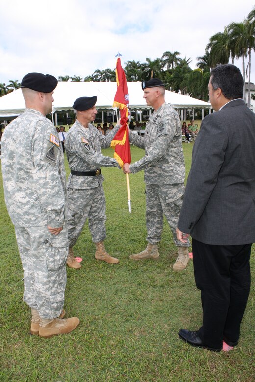Lt. Col. Thomas D. Asbery (back right) receives the unit colors from Pacific Ocean Division Commander Brig. Gen. Richard L. Stevens becoming the 68th Commander of the U.S. Army Corps of Engineers, Honolulu District today. Looking on are outgoing District Commander Lt. Col. Douglas B.  Guttormsen (front left) and Anthony J. Paresa, Deputy District Engineer and Chief, Programs and Project Management Division. Stevens hosted the ceremony at Historic Palm Circle Parade Field at Fort Shafter, Hawaii. For his outstanding work and contributions to the Honolulu District, Guttormsen received the Meritorious Service Medal. Guttormsen leaves to become the Division Engineer for the 25th Infantry Division, Schofield Barracks, Hawaii. Asbery most recently served as the Executive Officer to the Commanding General, Human Resources Command, Fort Knox, Kentucky.  Asbery deployed twice in support of Operation Iraqi Freedom. He also deployed to the Mississippi Coast in support of Hurricane Katrina disaster relief efforts in 2005 as a Forward Engineer Support Team leader. Photo by Dino W. Buchanan, Honolulu District Public Affairs.