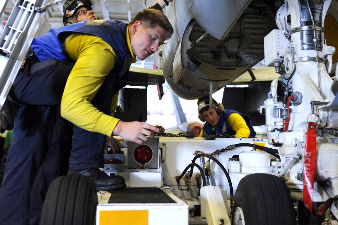 U.S. Navy Seaman Thomas Payne guides U.S. Navy Petty Officer 2nd Class Trevor Grimes as he hooks a spotting dolly to an F/A-18C Hornet aircraft assigned to Strike Fighter Squadron 146 on the USS Nimitz during Rim of the Pacific 2012, an exercise in the Pacific Ocean off Hawaii, July 10, 2012. Payne and Grimes are aviation boatswain's mates airmen. More than 25,000 people from 22 nations are participating in the exercise to foster and sustain international cooperation on the world's oceans.