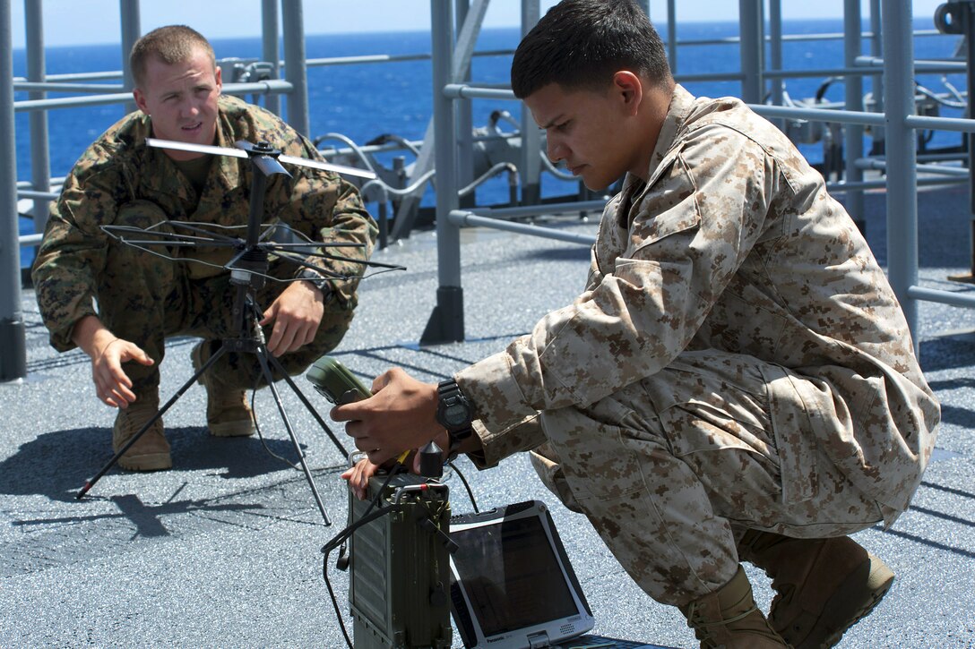 U.S. Marine Corps Pvt. David Phelan, left, and Marine Corps Sgt. Vincent Flores, right, attempt to acquire a signal with secure data communication equipment on a weather deck aboard the USS Essex during Rim of the Pacific 2012 in the Pacific Ocean, July 12, 2012. Phelan and Flores are assigned to Alpha Company, 3rd Reconnaissance Battalion.