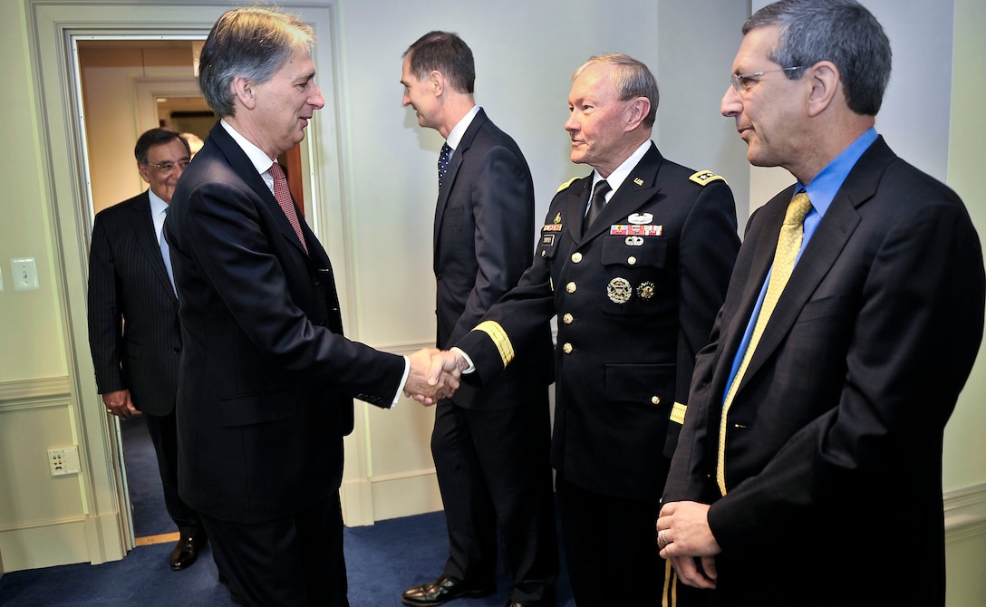 British Defense Secretary Philip Hammond shakes hands with U.S. Army Gen. Martin E. Dempsey, chairman of the Joint Chiefs of Staff, at the Pentagon, July 18, 2012.