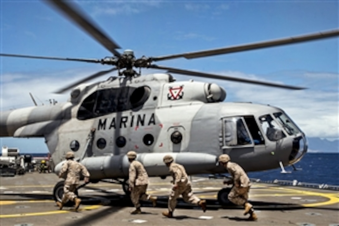 U.S. Marines prepare to enter a Mexican navy MI-17 helicopter aboard the Mexican navy transport ship ARM Usumacinta during Rim of the Pacific 2012, an exercise in the Pacific Ocean near the Hawaiian Islands, July 12, 2012.