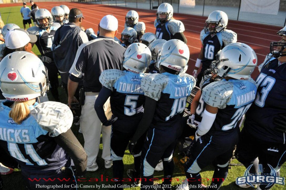 Lt. Kristin Love, number 19 and division officer of the Patient Administration Department, Naval Hospital, Marine Corps Base Camp Pendleton, leans around San Diego Surge team-mate to better hear her coach. This is Loves first season playing tackle football with the Women’s Football Alliance. Photo by Cali Camera, Rashad Griffin Sr.