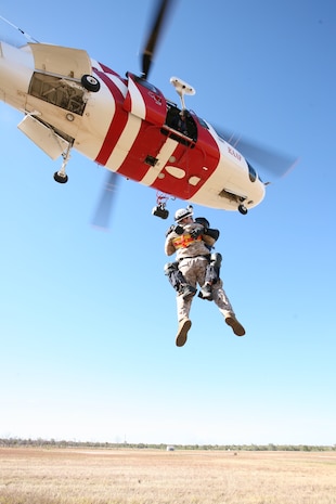 Joel Nas, a search and rescue crewman, and Petty::r::::n::Officer 2nd Class Darin Buckley, a Marine Fighter Attack Squadron 232 corpsman, execute a double winch here::r::::n::July 18, 2012, as part of Southern Frontier 2012. SF12 is an annual, unilateral training exercise hosted by the::r::::n::Royal Australian Air Force allowing Marine Aircraft Group 12 F/A-18 squadrons, like Marine Fighter Attack::r::::n::Squadron 232, the opportunity to focus on offensive-air Support training in order to improve squadron readiness.K