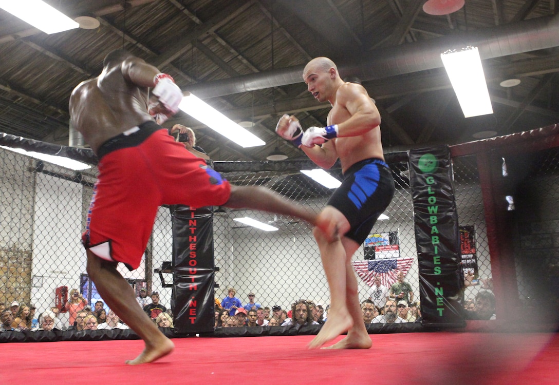 Sgt. David Lafayette (left) with Wrights Extreme Martial Arts, delivers a kick to his opponent Adam Miller during Battle in the South IV hosted at the Coastline Convention Center in Wilmington, N.C. July 14. The event featured 12 bouts and two of them included devil dogs from Marine Corps Base Camp Lejeune.