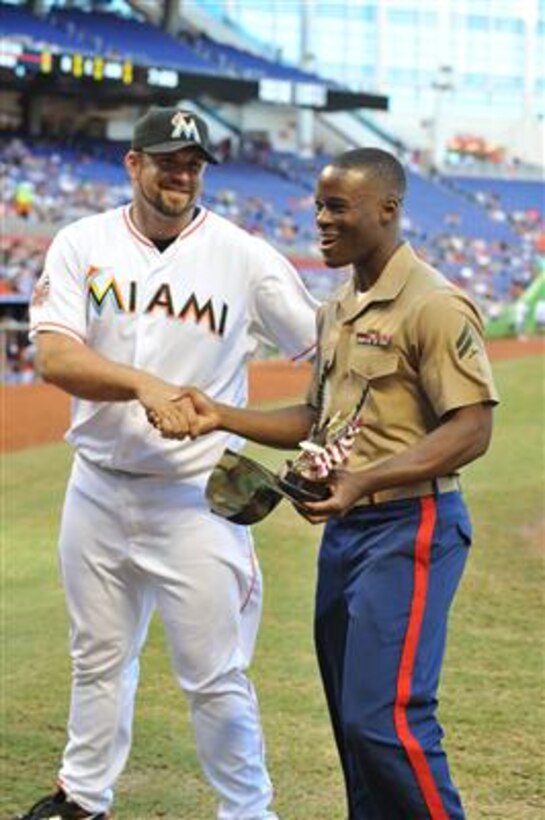 U.S. Marine Corporal Luchmy Luc, a 22-year-old native of Hollywood, Fla., is all smiles as he shakes hands with Heath Bell, a relief pitcher for the Miami Marlins. Luc, an administrative clerk with U.S. Marine Corps Forces, South, was recognized as the Marlins' Soldier of the Game, June 11. The 2008 graduate of South Broward High School said he was honored to be recognized by his hometown team. 