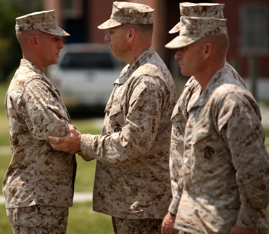 1st Sgt. Cole Daunhauer, company first sergeant of Utilities Instruction Company at the Marine Corps Engineer School aboard Marine Corps Base Camp Lejeune, shakes hands with Brig. Gen. John Simmons, commanding general of Training Command in charge of MCES, after being awarded the Bronze Star aboard MCB Camp Lejeune July 18 for his actions while deployed in support of Operation Enduring Freedom. Daunhauer was deployed with 3rd Battalion, 2nd Marine Regiment from March 1 to Aug. 31, 2011.