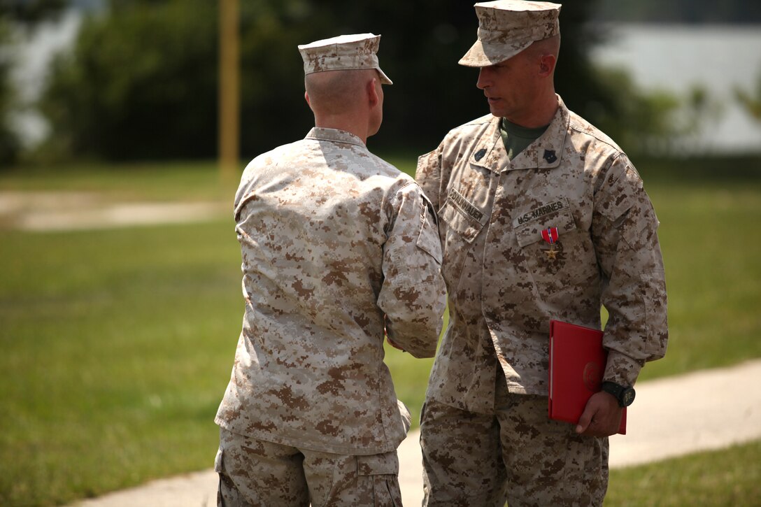 1st Sgt. Cole Daunhauer, company first sergeant of Utilities Instruction Company at the Marine Corps Engineer School aboard Marine Corps Base Camp Lejeune, is congratulated for receiving the Bronze Star aboard MCB Camp Lejeune July 18 for his actions while deployed with 3rd Battalion, 2nd Marine Regiment in support of Operation Enduring Freedom.