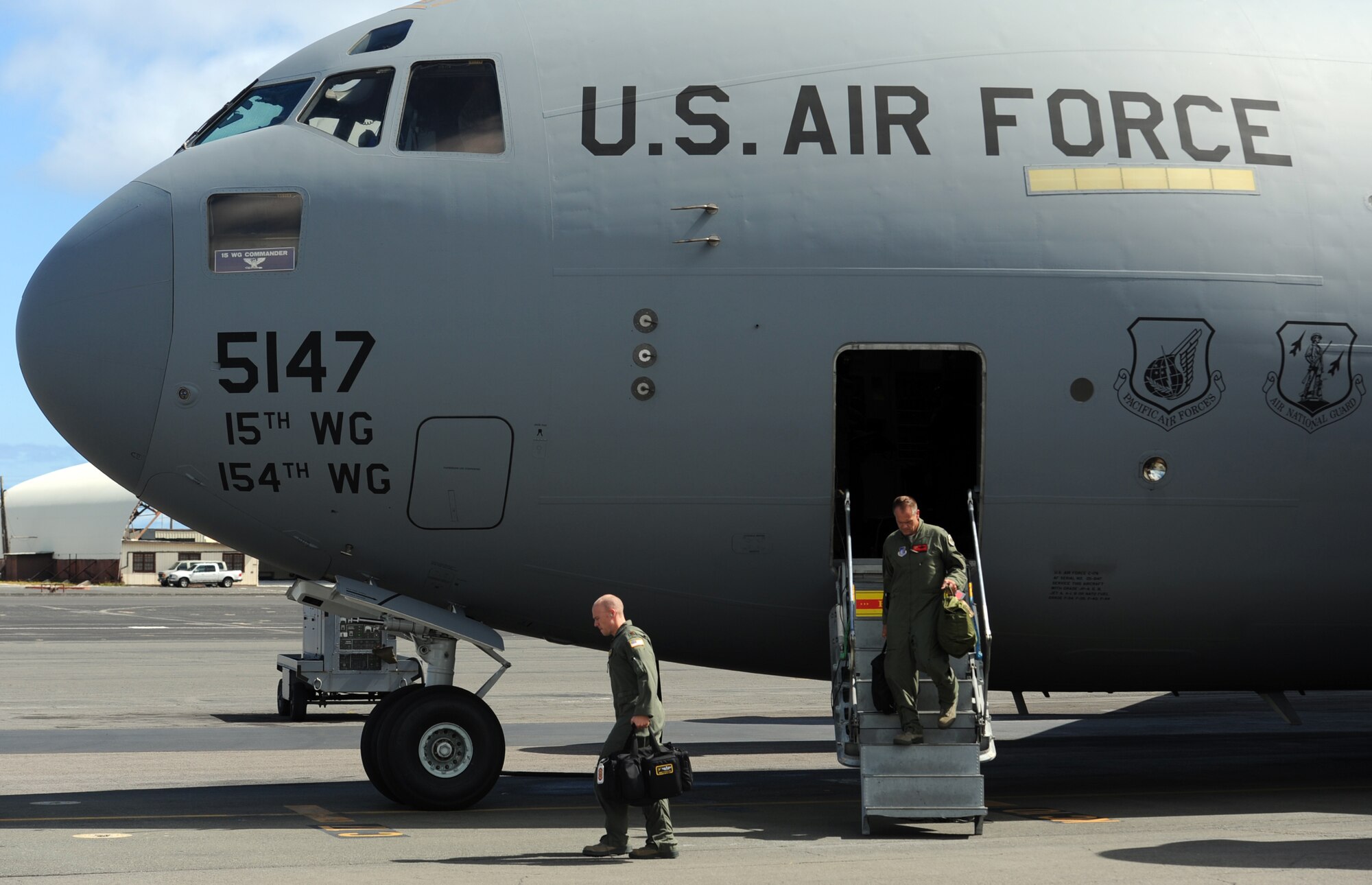 Col. Johnny Roscoe, 15th Wing commander (right), exits a C-17 Globemaster III from the 535th Airlift Squadron at Joint Base Pearl Harbor-Hickam, Hawaii, with Maj. James Pasquino, 15th Wing executive officer, July 18 following Roscoe's first flight since taking command of the 15th Wing. The flight was part of the Rim of the Pacific military exercise; the largest naval exercise in the world. (U.S. Air Force photo by Staff Sgt. Nathan Allen)