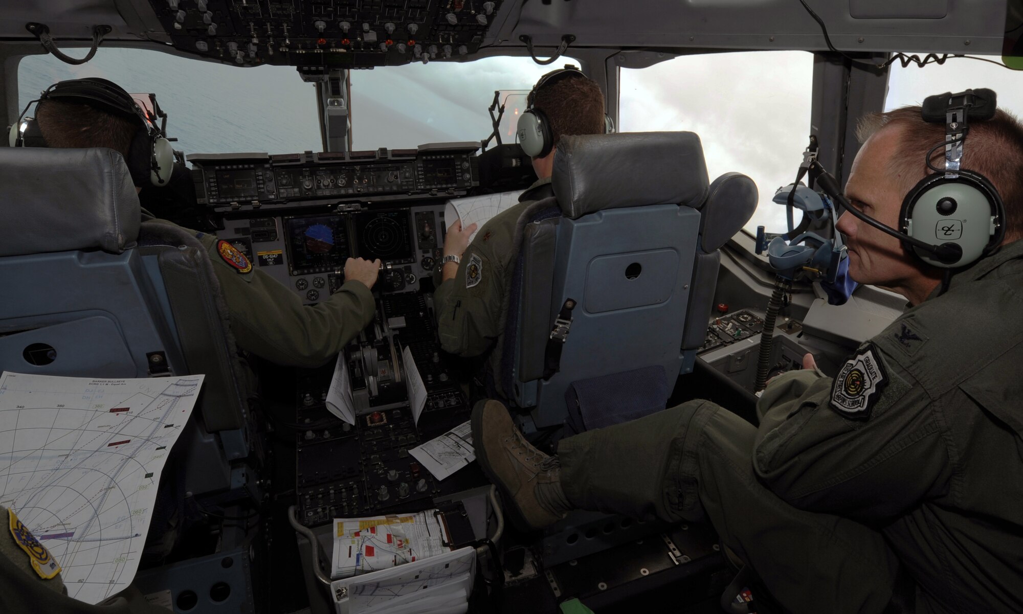 Col. Johnny Roscoe, 15th Wing commander (right), flies on a local sortie over the Pacific Ocean aboard a C-17 Globemaster III from the 535th Airlift Squadron at Joint Base Pearl Harbor-Hickam, Hawaii, piloted by 1st. Lt. Donald Hilton, from the 535th AS, and Maj. James Pasquino, 15th Wing executive officer, July 18 during Roscoe's first flight since taking command of the 15th Wing. The flight was part of the Rim of the Pacific military exercise; the largest naval exercise in the world. (U.S. Air Force photo by Capt. Ben Sakrisson)