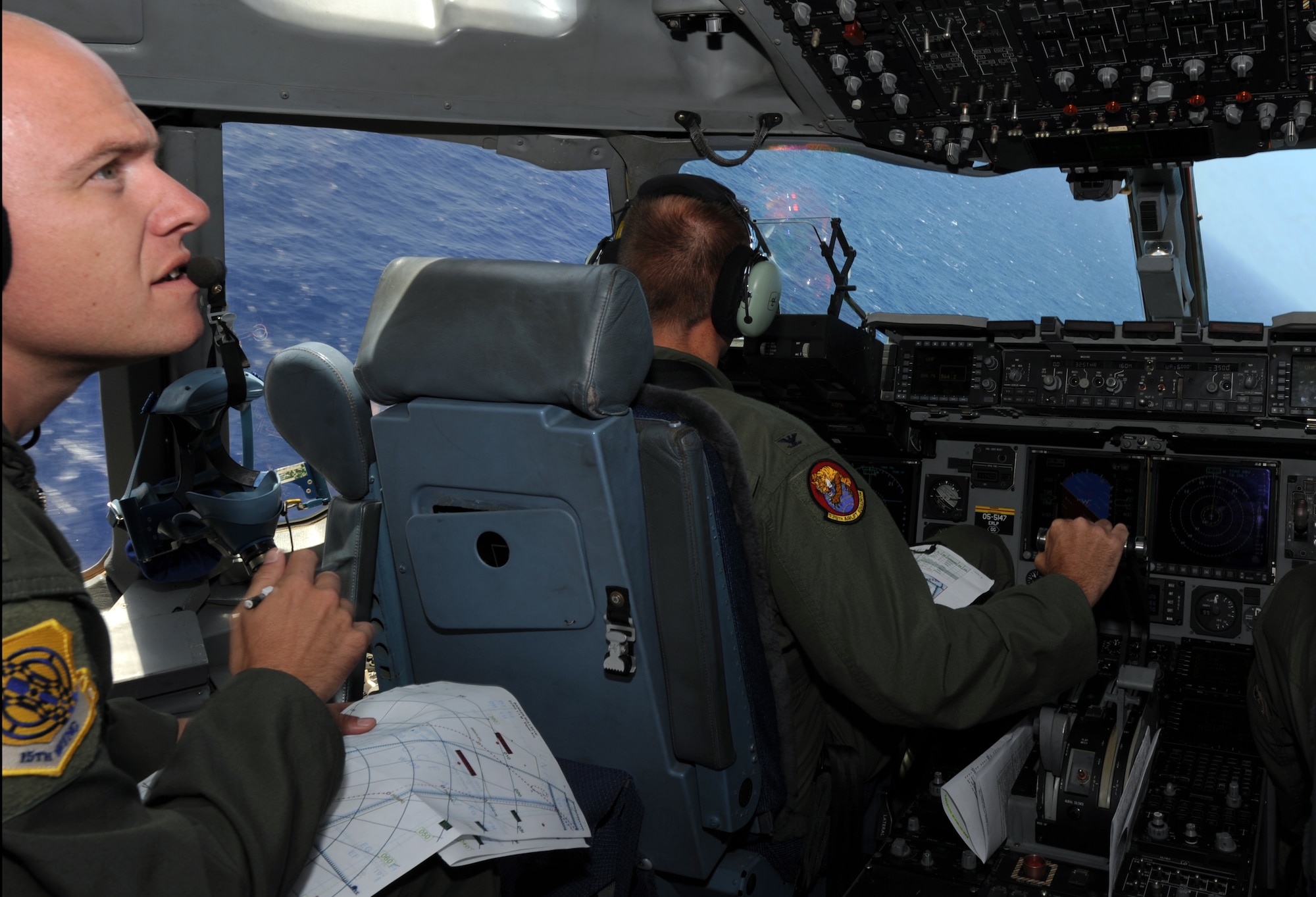 Col. Johnny Roscoe, 15th Wing commander, pilots a C-17 Globemaster III from the 535th Airlift Squadron at Joint Base Pearl Harbor-Hickam, Hawaii, while Maj. James Pasquino, 15th Wing executive officer, scans the horizon July 18 during Roscoe's first flight since taking command of the 15th Wing. The flight was part of the Rim of the Pacific military exercise; the largest naval exercise in the world. (U.S. Air Force photo by Capt. Ben Sakrisson)