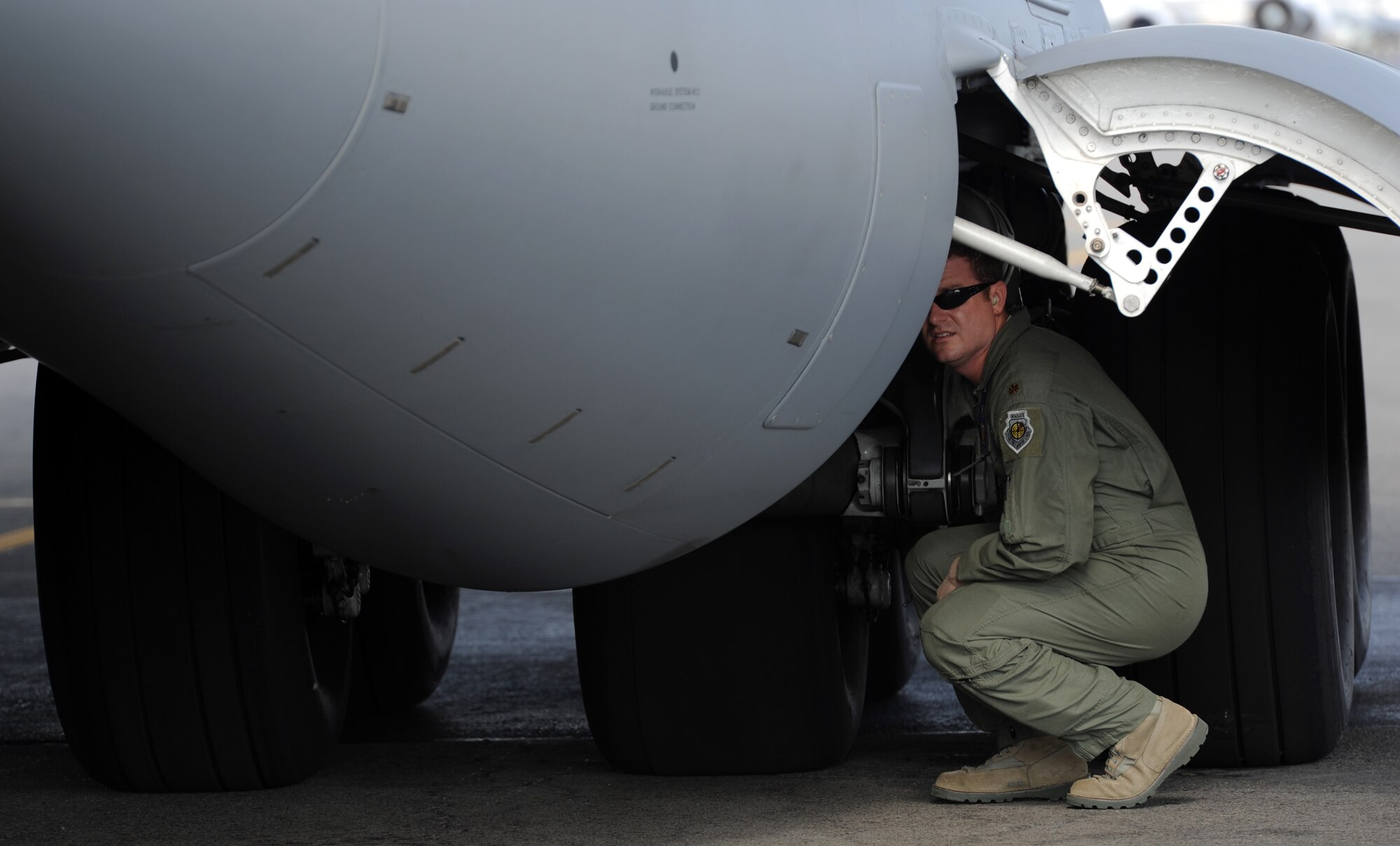 Maj. Alan Partridge, 15th Wing commander's action group, performs a pre-flight inspection of the landing gear on a C-17 Globemaster III from the 535th Airlift Squadron at Joint Base Pearl Harbor-Hickam, Hawaii, July 18 prior to Col. Johnny Roscoe's, 15th Wing Commander's, first flight since taking command of the 15th Wing. The flight was part of the Rim of the Pacific military exercise; the largest naval exercise in the world. (U.S. Air Force photo by Capt. Ben Sakrisson)