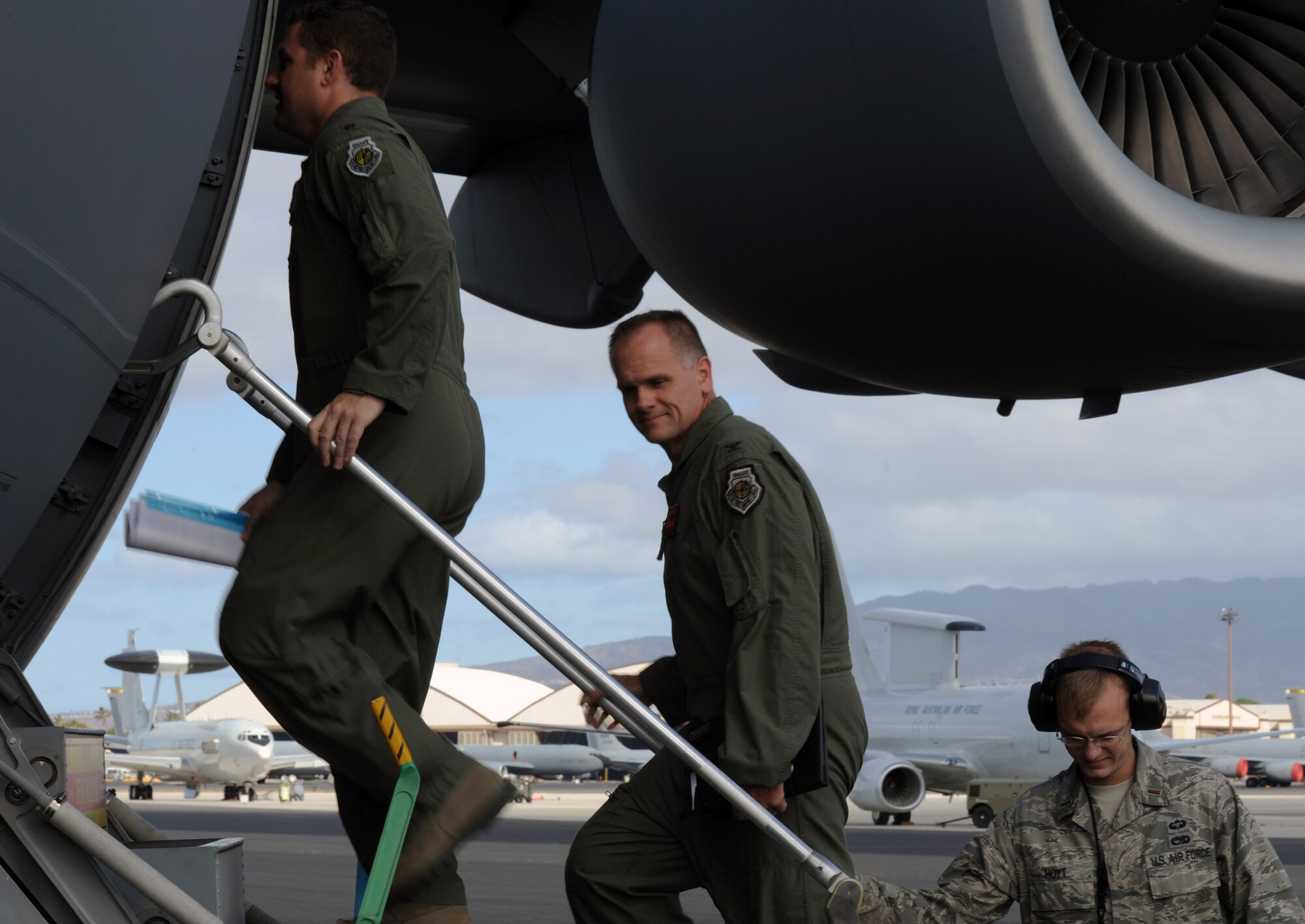 Col. Johnny Roscoe, 15th Wing commander, and Maj. Alan Partridge, 15th Wing commander's action group, board a C-17 Globemaster III from the 535th Airlift Squadron at Joint Base Pearl Harbor-Hickam, Hawaii, after greeting the maintenance officer, 2nd. Lt. Greg Hoyt, 15th Aircraft Maintenance Squadron, July 18 prior to Roscoe's first flight since taking command of the 15th Wing. The flight was part of the Rim of the Pacific military exercise; the largest naval exercise in the world. (U.S. Air Force photo by Capt. Ben Sakrisson)