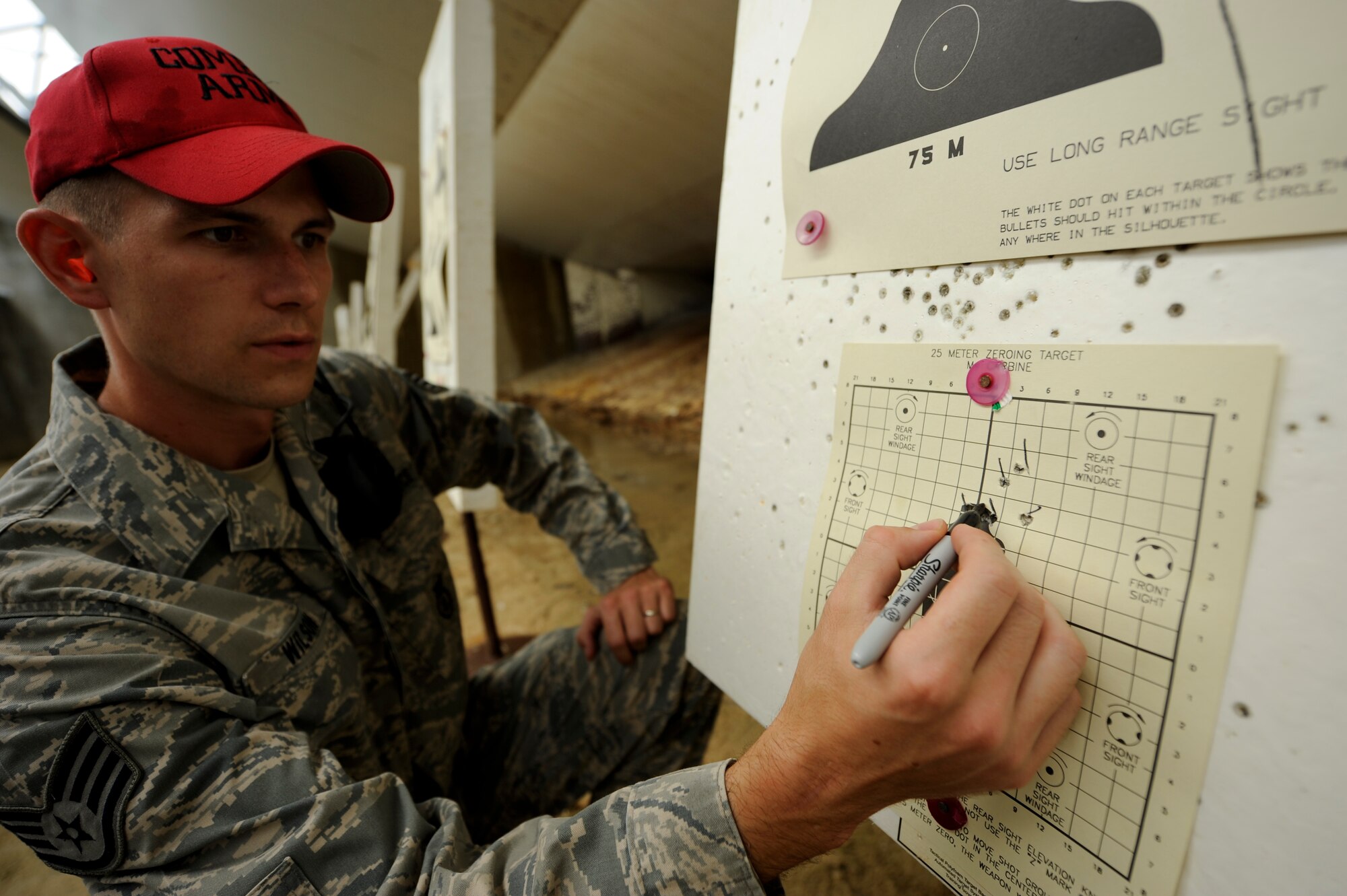 U.S. Air Force Staff Sgt. Thomas Wilson, Combat Arms Instructor, reviews a qualifying Airman's zeroing target and makes sight corrections at the CA firing range on Kadena Air Base, Japan, July 16, 2012. Air Force CA implemented a new qualification course Dec. 1, 2011, which is staged to give a more realistic feel to the students by incorporating a few new qualification portions, including movement and even three-round burst divisions. (U.S. Air Force photo/ Airman 1st Class Maeson L. Elleman)