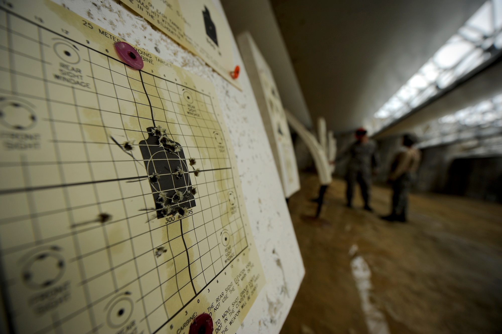 U.S. Air Force Tech. Sgt. Jose Sedas-Reyes, Combat Arms instructor, reviews a qualifying Airman's zeroing target and indicates sight corrections at the CA firing range on Kadena Air Base, Japan, July 16, 2012. CA initiated a new firing qualification course for Airmen around the Air Force beginning in December 2011. Kadena, which began teaching the course a month prior to the initiation deadline for the Air Force, has doubled the average pass rates for each class since the course began. (U.S. Air Force photo/ Airman 1st Class Maeson L. Elleman)