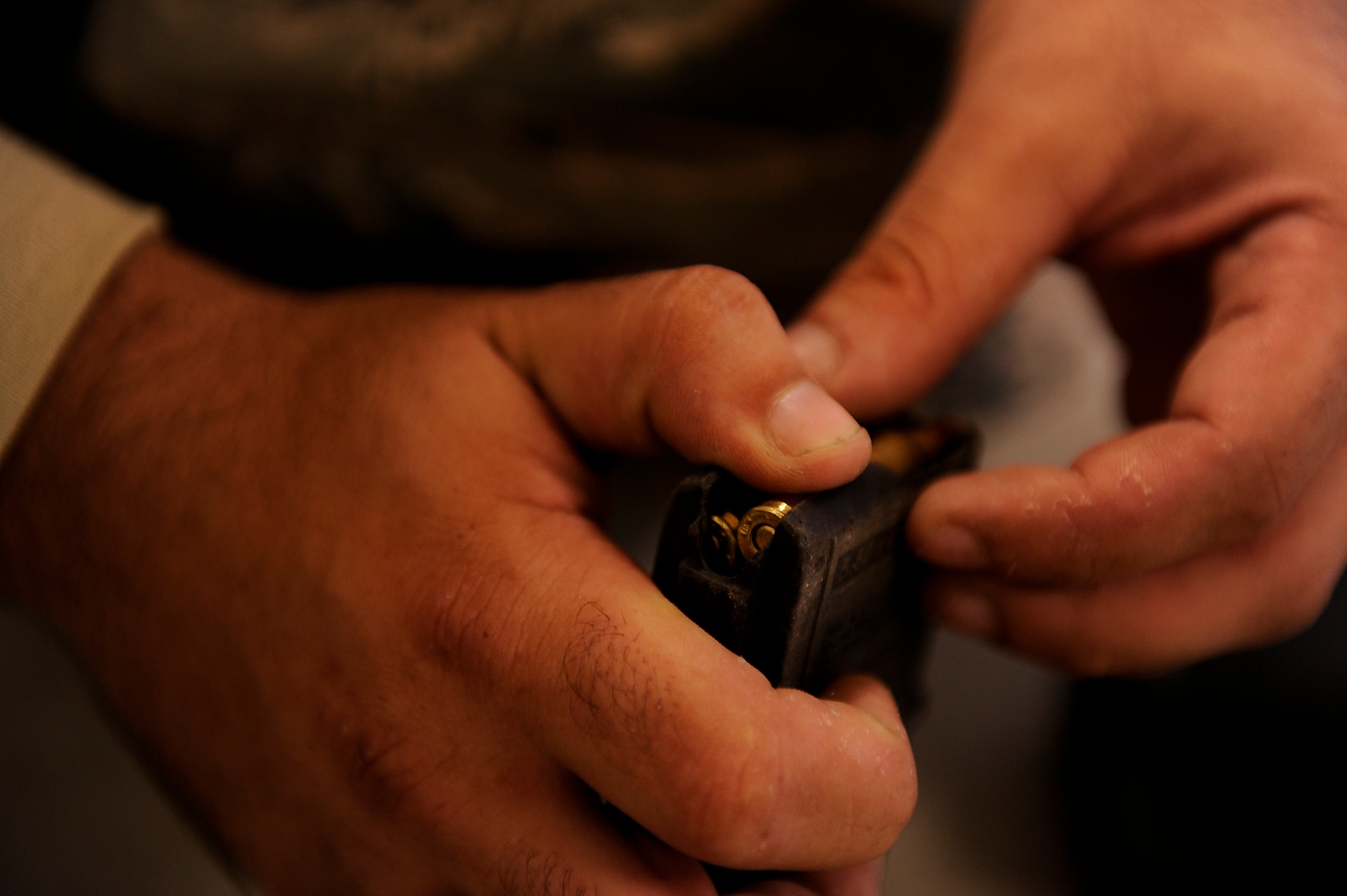 A Combat Arms student loads a magazine for an M-4 Carbine during his pre-deployment weapons qualification training on Kadena Air Base, Japan, July 16, 2012. The U.S. Air Force implemented a new weapons qualification course in December in order to incorporate a more realistic training program for Airmen set to deploy. (U.S. Air Force photo/ Airman 1st Class Maeson L. Elleman)