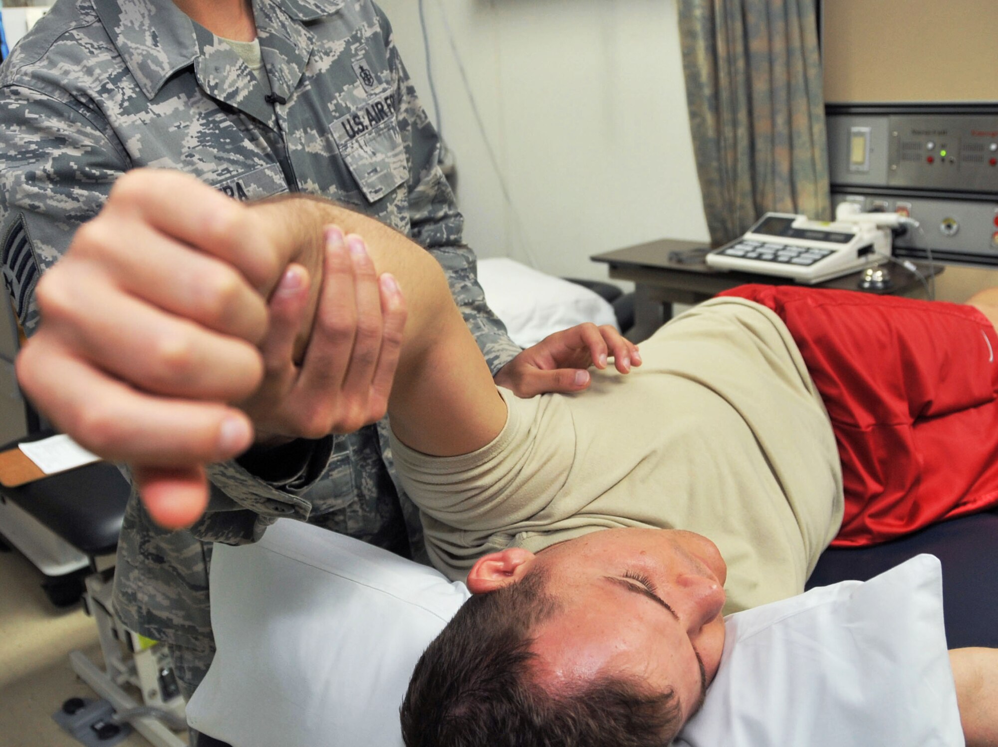 Staff Sgt. Kenneth Rivera manipulates Senior Airman Marshall Hunsaker’s left arm to increase his range of motion at the 51st Medical Operations Squadron Physical Therapy clinic, July 19, 2012. Hunsaker, a 51st Fighter Wing Public Affairs broadcaster, is recovering from a left shoulder labrum surgery after a sports injury while deployed. Physical therapy is a form of rehab to get patients functioning at normal levels through various exercises, manipulation and strengthening. (U.S. Air Force photo/Staff Sgt. Stefanie Torres)