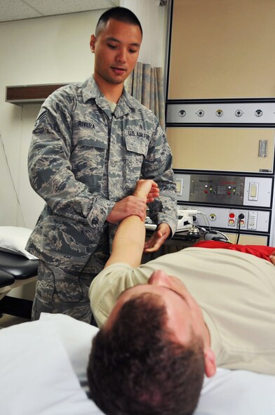 Staff Sgt. Kenneth Rivera manipulates Senior Airman Marshall Hunsaker’s left arm to increase his range of motion at the 51st Medical Operations Squadron Physical Therapy clinic, July 19, 2012. The five-person team in the clinic sees an average of 60 patients a week who are recovering from musculoskeletal injuries and surgeries. Rivera is a 51st MDOS physical therapy craftsman, and Hunsaker is a 51st Fighter Wing Public Affairs broadcaster. (U.S. Air Force photo/Staff Sgt. Stefanie Torres)