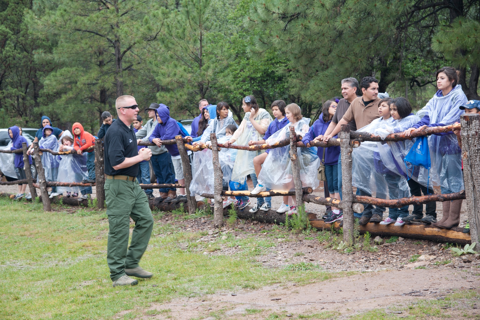 A member of the 49th Security Forces Squadron Military Working Dogs Section discusses various tactics and uses for military working dogs at the Mayhill, N.M., Camp of the Tall Pines July 17. Members of the 49th SFS demonstrated the military working dogs’ capabilities to participants in the Candlelighters for Children with Cancer program as a way of boosting the children’s morale and giving back to the community. (U.S. Air Force Photo by Airman 1st Class Anthony M. Ward/Released)