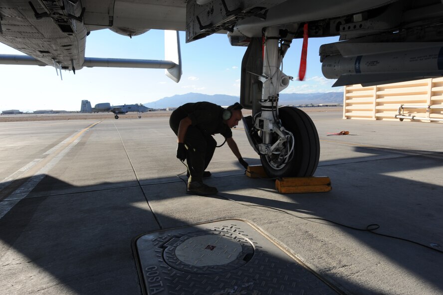 U.S. Air Force Staff Sgt. Nicholas Nelson, a crew chief with the 23d Aircraft Maintenance Squadron, 74th Aircraft Maintenance Unit, chocks an A-10C Thunderbolt II at Nellis Air Force Base, Nev., July 16, 2012, during exercise Red Flag 12-4.  Nelson said Red Flag is a learning experience that he compares to his recent deployment to Afghanistan.  He said Red Flag is as close as you can get to the “real thing” without being deployed to the Afghanistan area of responsibility.  (U.S. Air Force photo by Master Sgt. Sonny Cohrs/Released)   