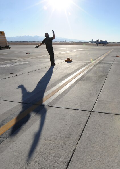 U.S. Air Force Staff Sgt. Nicholas Nelson, a crew chief with the 23d Aircraft Maintenance Squadron, 74th Aircraft Maintenance Unit, guides an A-10C Thunderbolt II into position at Nellis Air Force Base, Nev., following a training mission at the Nevada Training and Test Range July 16, 2012.  The 74th AMU is deployed to Nellis in support of the Red Flag 12-4 exercise, which runs July 16-27, 2012. Fourteen A-10s are deployed to Nellis from Moody Air Force Base, Ga., along with more than 200 aircrew, maintainers and support personnel.  (U.S. Air Force photo by Master Sgt. Sonny Cohrs/Released)