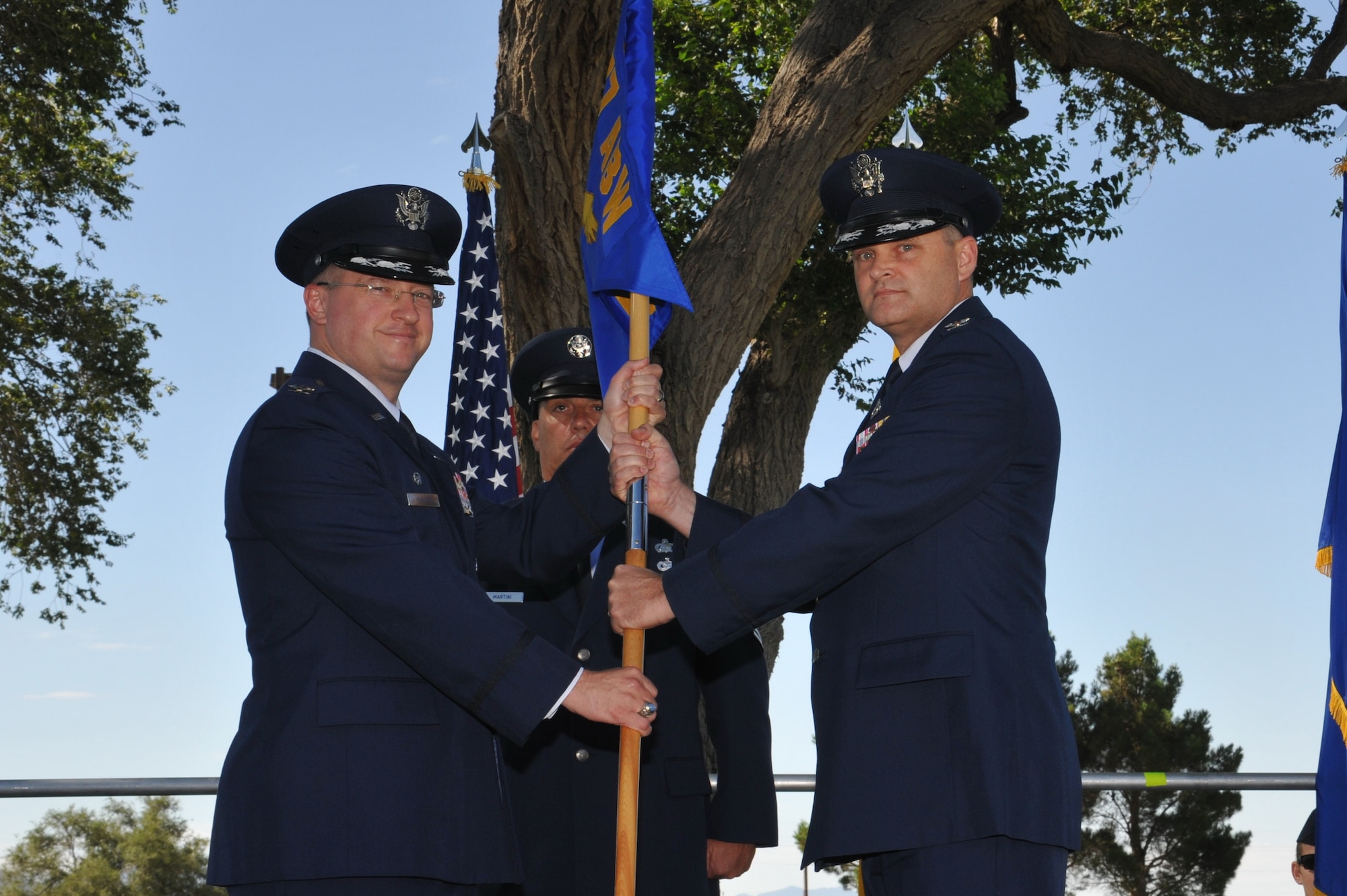 KIRTLAND AFB, N.M. – Col. John Kubinec, 377th Air Base Wing commander, left, passes the guidon to Col. Jeffrey Lanning, 377th Mission Support Group commander, during the 377 MSG change of command ceremony Tuesday outside of the Mountain View Club. (Photo by Ken Moore)
