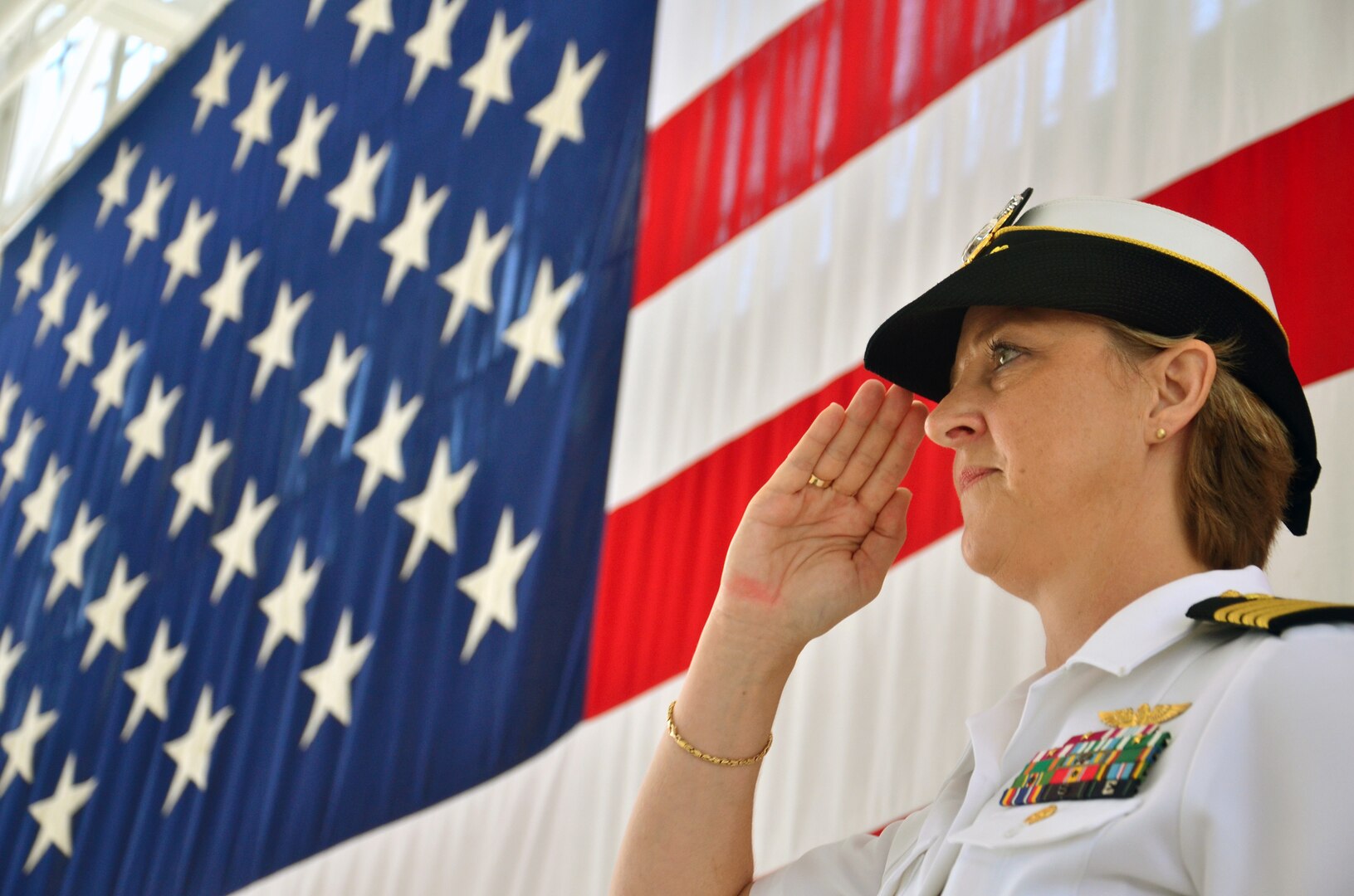 Navy Capt. Gail Hathaway salutes during colors at the Navy Medicine Education and Training Command change of command ceremony at the Naval Air Station Jacksonville., Fla., ceremonial hangar July 11. Hathaway, reporting from her previous assignment as the Medical Education and Training Campus deputy commandant at Joint Base San Antonio-Fort Sam Houston, assumed command during the hour-long ceremony.  (U.S. Navy photo by Larry Coffey)