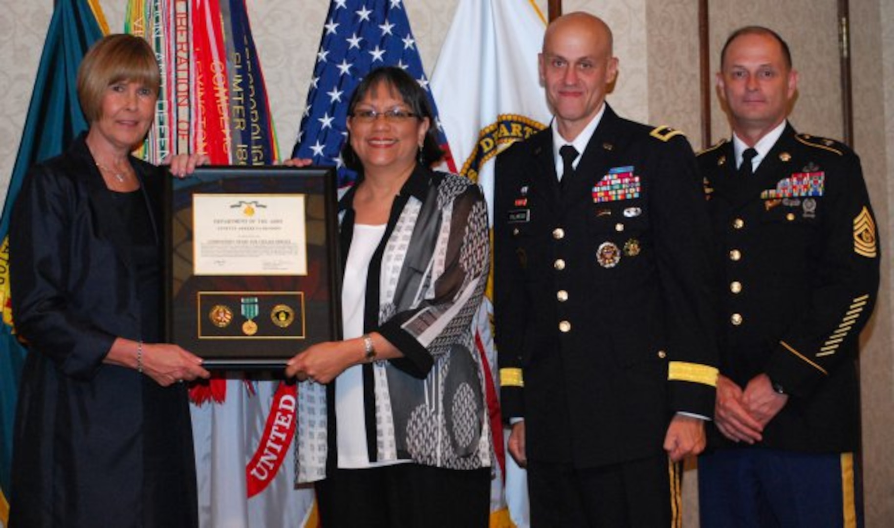 Ann Arkeketa-Rendon is awarded the Commander's Award for Civilian Service from Dr. Carol Lowman during an awards ceremony May 16 at Redstone Arsenal, Ala., after being named the Army Contracting Command's Small Business Specialist of the Year for 2011. Lowman is the deputy to the commanding general at ACC. Also pictured are Brig. Gen. Kirk Vollmecke, the Mission and Installation Contracting Command commanding general, and ACC Command Sgt. Maj. John Murray. (Photo by Larry McCaskill)