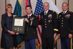 Maj. Christopher Center is awarded the Army Commendation Medal from Dr. Carol Lowman during an awards ceremony May 16 at Redstone Arsenal, Ala., after being named the Army Contracting Command's Outstanding Contingency Contracting Officer for 2011. Lowman is the deputy to the commanding general at ACC. Also pictured are Brig. Gen. Kirk Vollmecke, the Mission and Installation Contracting Command commanding general, and ACC Command Sgt. Maj. John Murray. (Photo by Larry McCaskill)