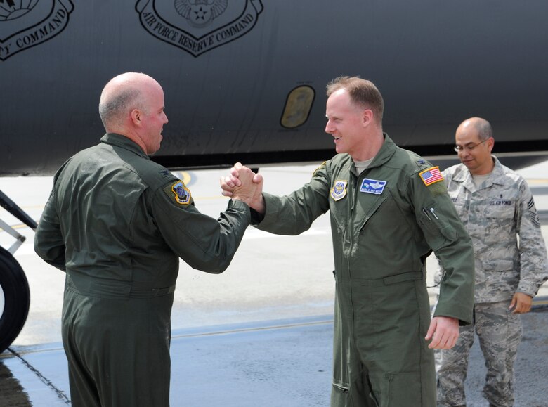 Col. Paul Guemmer, 92nd Air Refueling Wing commander, is greeted by Col. Marc Van Wert, 92nd ARW vice commander, after completing his final flight at Fairchild Air Force Base, Wash., July 17, 2012. The final flight is an aviation tradition in which aircrew members, upon completion of their last flight with the wing, or "fini flight," are met and hosed down with water by their unit comrades, family and friends. (U.S. Air Force photo by Airman 1st Class Ryan Zeski)