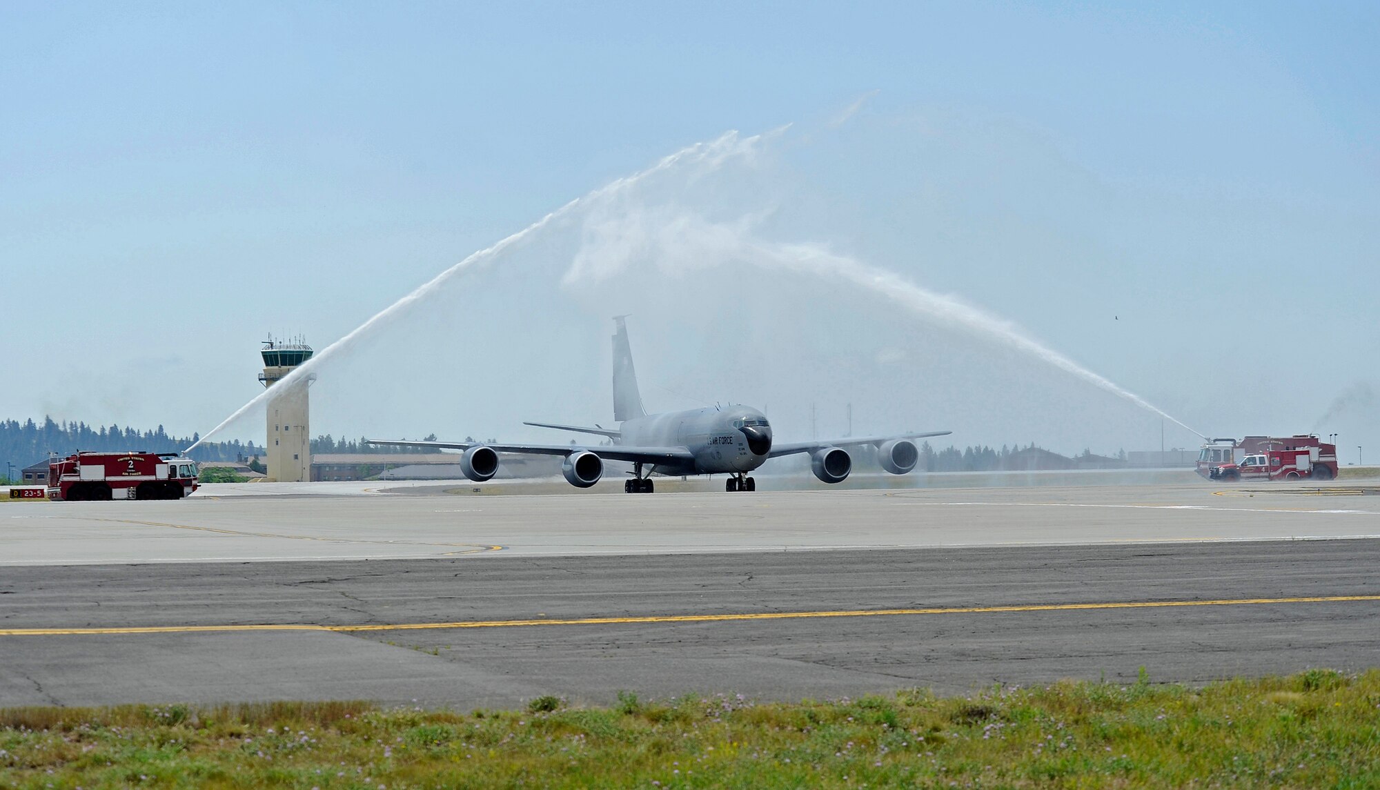 Col. Paul Guemmer, 92nd Air Refueling Wing commander, taxis through an archway of water upon completion of his final flight at Fairchild Air Force Base, Wash., July 17, 2012. The final flight is an aviation tradition in which aircrew members, upon completion of their last flight with the wing, or "fini flight," are met and hosed down with water by their unit comrades, family and friends. (U.S. Air Force photo by Airman 1st Class Ryan Zeski)