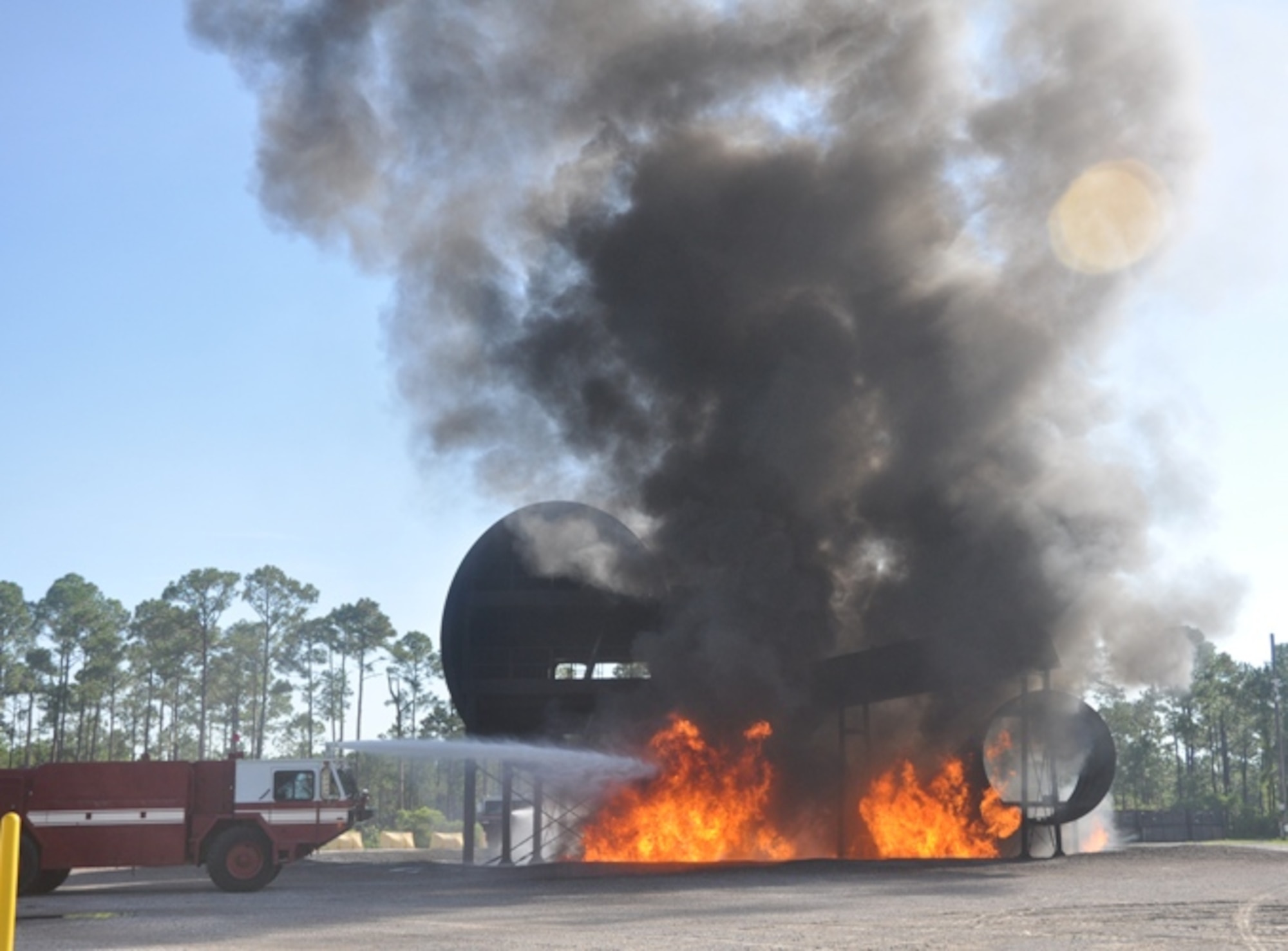Students use the P-19 Crash and Fire Rescue vehicle to douse the flames of a simulated jet fuel spill. (U.S. Air Force photo by 2nd Lt. Andrea Valencia)