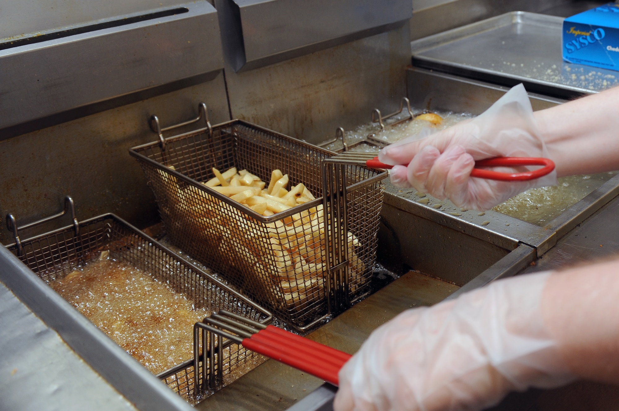 U.S. Air Force Airman 1st Class Caleb McGee, 4th Force Support Squadron food services apprentice, checks on the quality of french fries while they cook in the flight kitchen at Seymour Johnson Air Force Base, N.C., July 17, 2012. Onion rings, french fries and breaded cheddar cheese are side items offered at the flight kitchen. (U.S. Air Force photo/Airman 1st Class John Nieves Camacho/Released)
