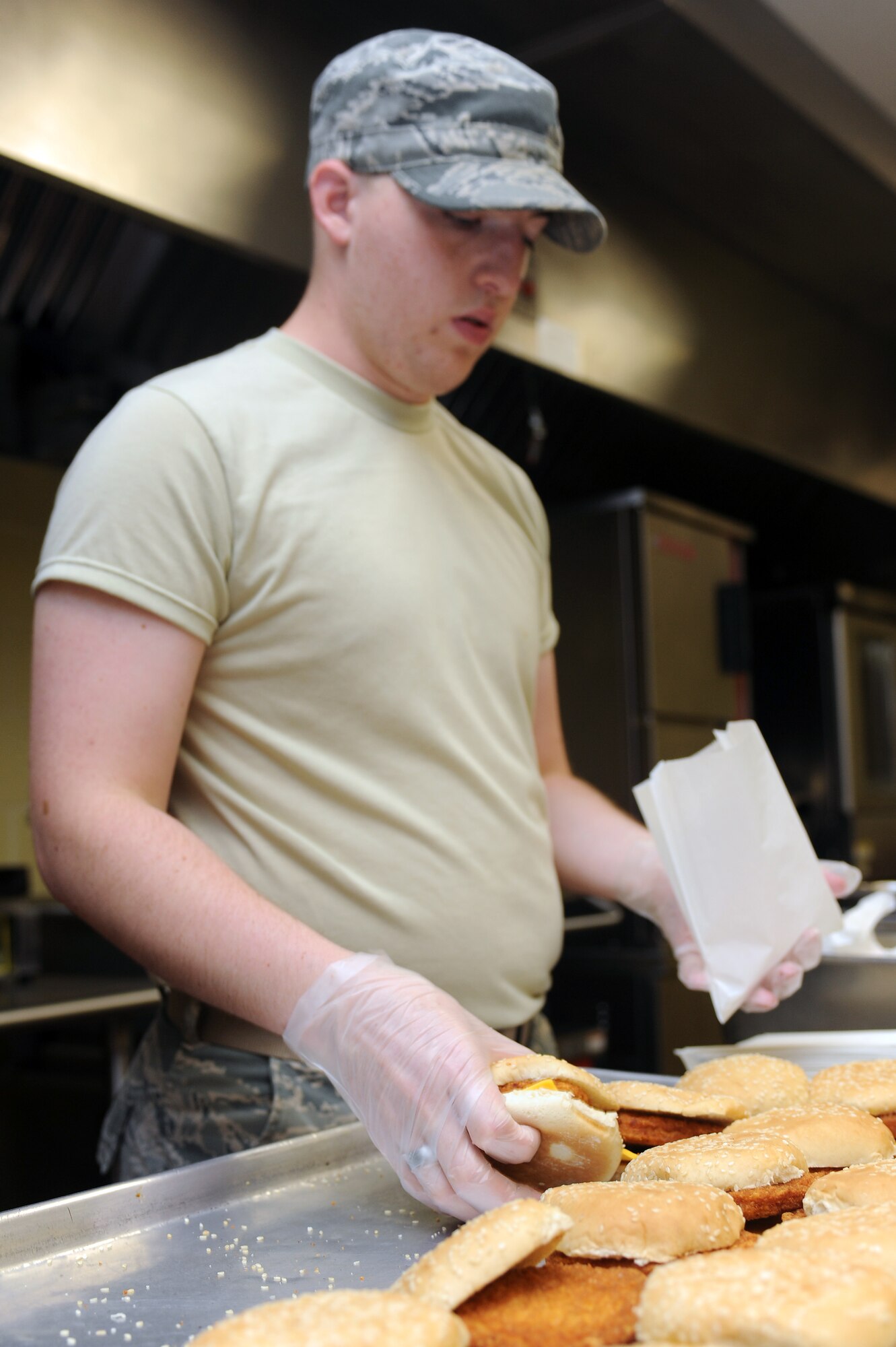 U.S. Air Force Airman 1st Class Caleb McGee, 4th Force Support Squadron food services apprentice, prepares a meal in the flight kitchen at Seymour Johnson Air Force Base, N.C., July 17, 2012. The flight kitchen serves a variety of sandwiches including breaded and herb-grilled chicken and bacon cheeseburgers. (U.S. Air Force photo/Airman 1st Class John Nieves Camacho/Released)
