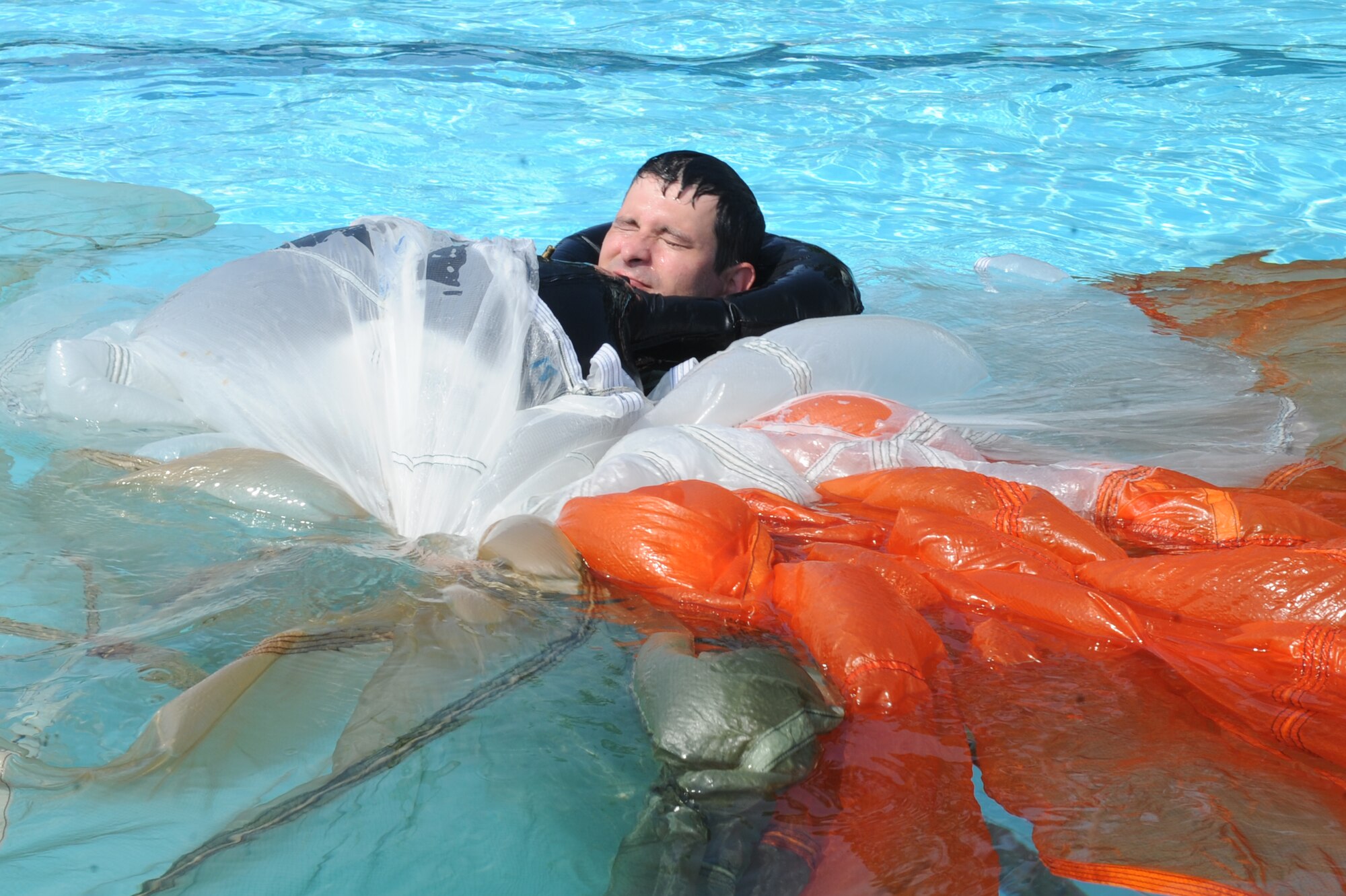 U.S. Air Force Maj. Trent Patterson, 334th Fighter Squadron pilot, performs a canopy disentanglement exercise during a survival, evasion, resistance and escape water survival course at Seymour Johnson Air Force Base, N.C., July 18, 2012. Aircrew members must learn to maneuver out from under a canopy in the disentanglement exercise. (U.S. Air Force photo/Airman 1st Class John Nieves Camacho/Released)