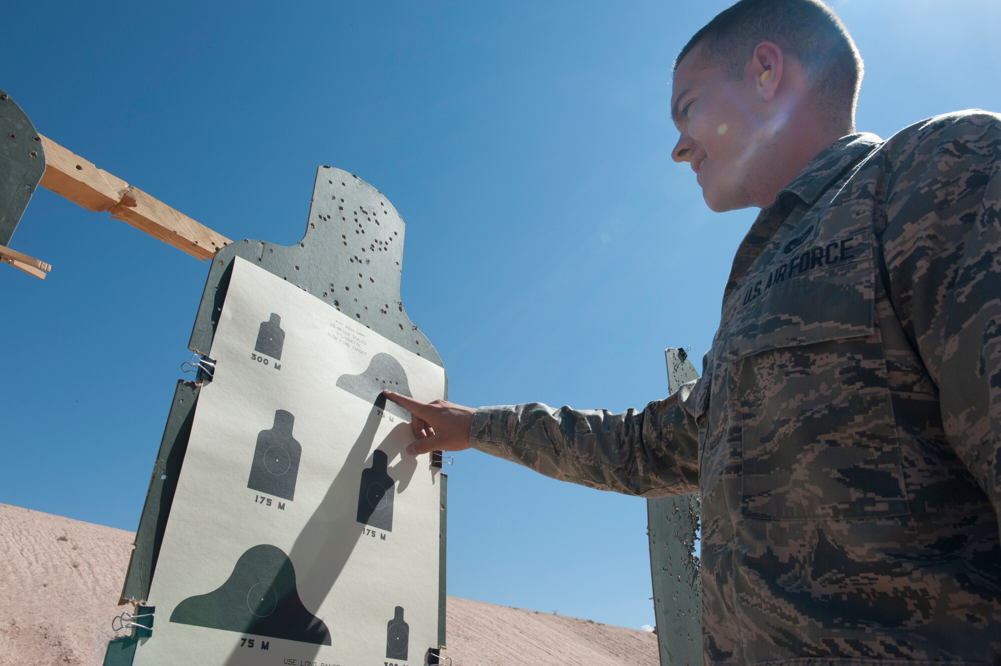 Airman 1st Class Andrew Lott, 49th Civil Engineer Squadron engineering assistant, reviews his shots on a target at the Holloman Air Force Base, N.M., Combat Arms Training and Maintenance range July 18. Lott was one of more than 20 Holloman Airmen who attended the basic rifle marksmanship and close-range combat training class from July 17-19. During this mandatory course, Airmen become more familiar with their weapons through a combination of classroom-taught material and time spent at the shooting range. (U.S. Air Force photo by Airman Leah Ferrante/Released)