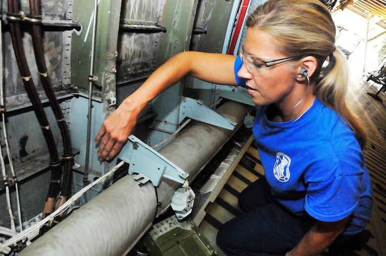 Christy Drew, sheet metal mechanic, shows where some of the C-5 end fittings are located in the cargo area of the aircraft. (U. S. Air Force photo/Sue Sapp)