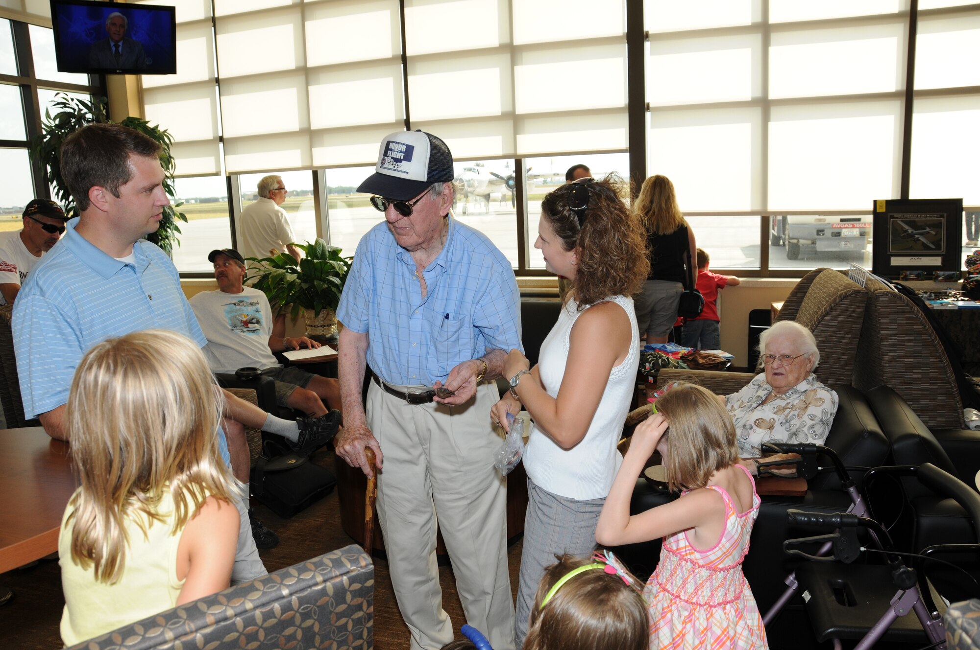 SIOUX FALLS, S.D. - United States Air Force Lt. Col. Wendell Hanson (Ret.) tells the story of a piece of shrapnel retrieved from his seat of a B-25 aircraft during World War II to his family while waiting to board a bomber similar to the one that he flew.  The B-25 and several other historical and modern aircraft will be on display during the Sioux Falls Airshow 2012 on July 21 and 22. (National Guard photo by Tech. Sgt. Quinton Young)(Released)