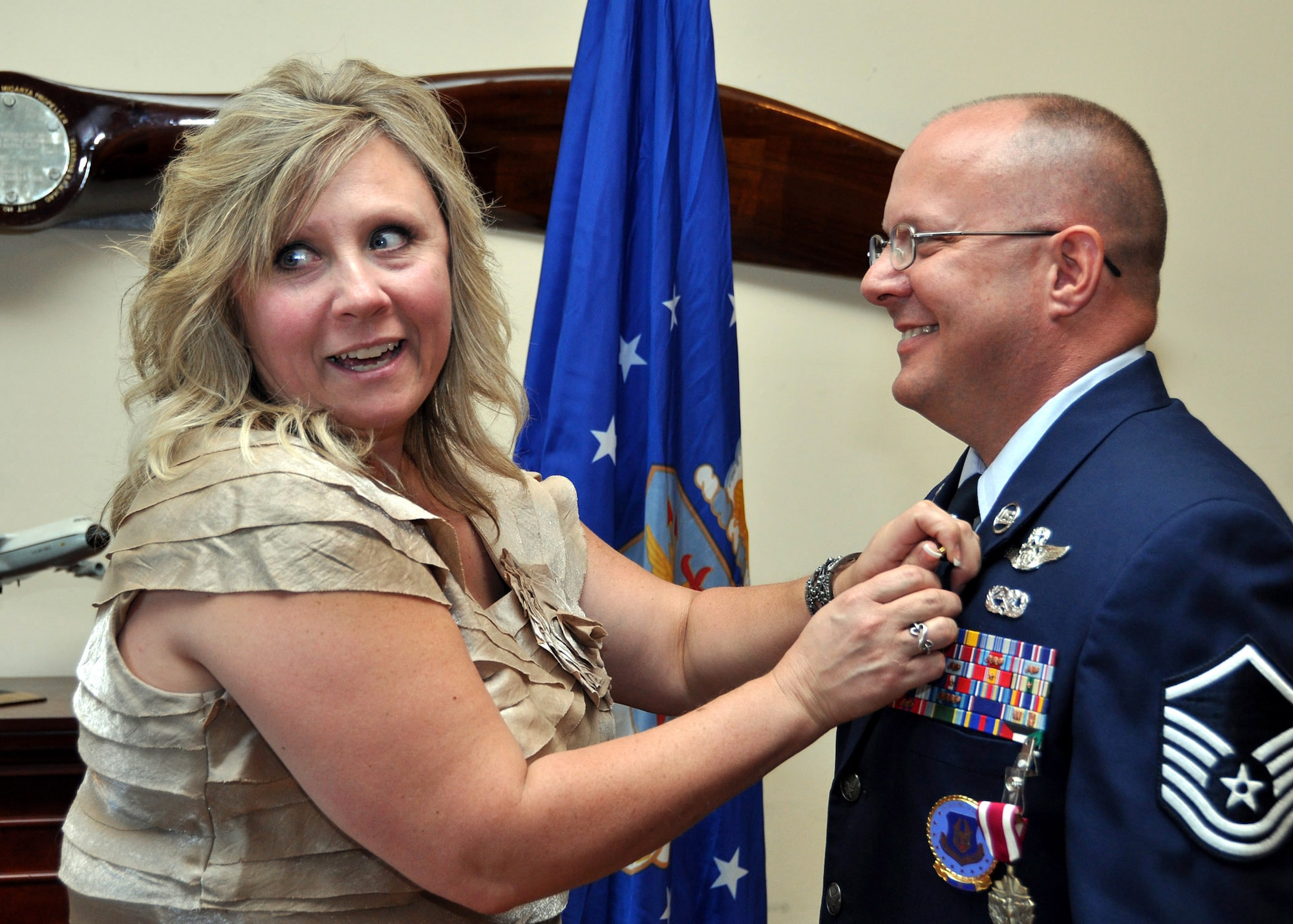 TRAVIS AIR FORCE BASE, Calif. -- Deana Burgin, wife of Master Sgt. Brian Burgin, 349th Air Mobility Wing Recruiting Squadron, pins a retirement pin on her husbandâ€™s lapel during his retirement ceremony June 24, 2012, at Travis Air Force Base, Calif. Sergeant Burgin is retiring after 26 years of service.  (U.S. Air Force photo/Tech. Sgt. Rachel Martinez)