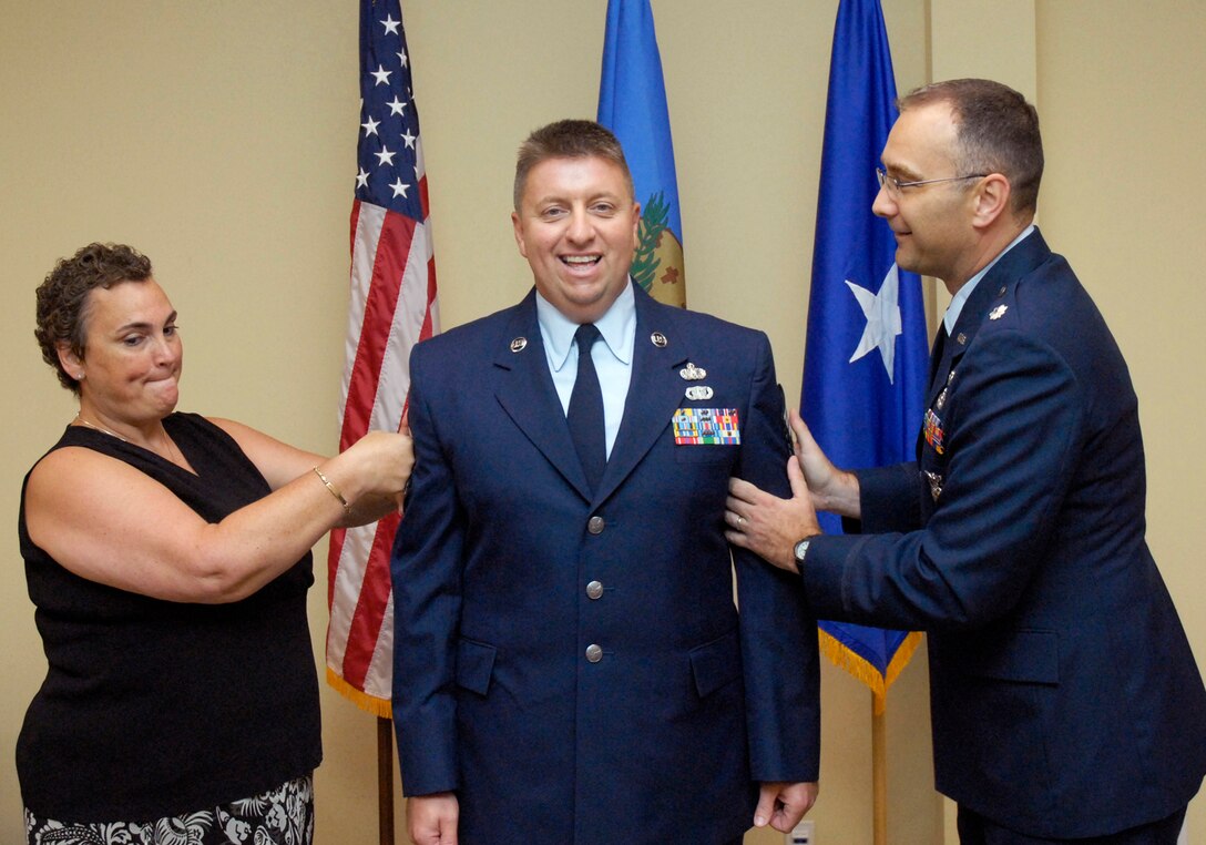 Chief Master Sergeant Bryan Blansett gets his new stripes
properly tacked on by his wife Mary Blansett and Lieutenant Colonel Martin
Keiner, 138th Civil Engineering Commander during his official ceremony, 15
July 2012.  (U.S. Air Force Photo By:  MSgt Preston Chasteen)