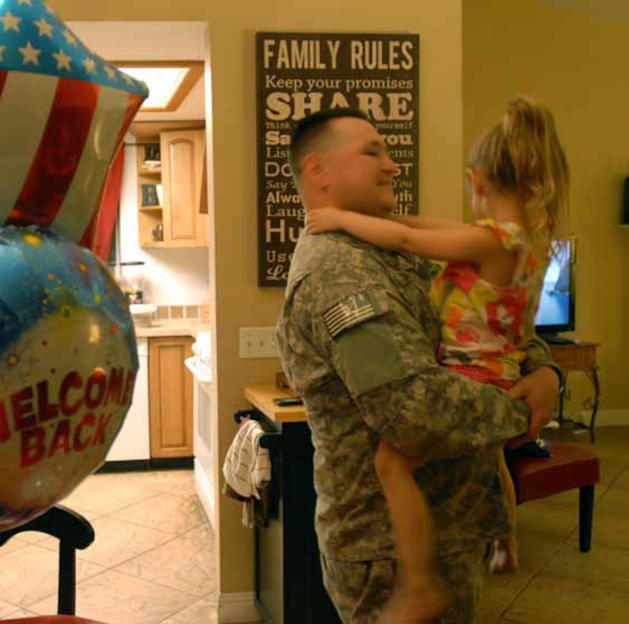 Staff Sgt. Elias Zubia is greeted by his 4-year-old daughter Delilah in the living room of their home. Delilah stayed up past her bedtime in order to be able to welcome her daddy home and show him the card she had made. (U.S. Army photos by Sgt. Tracy Ellingsen)