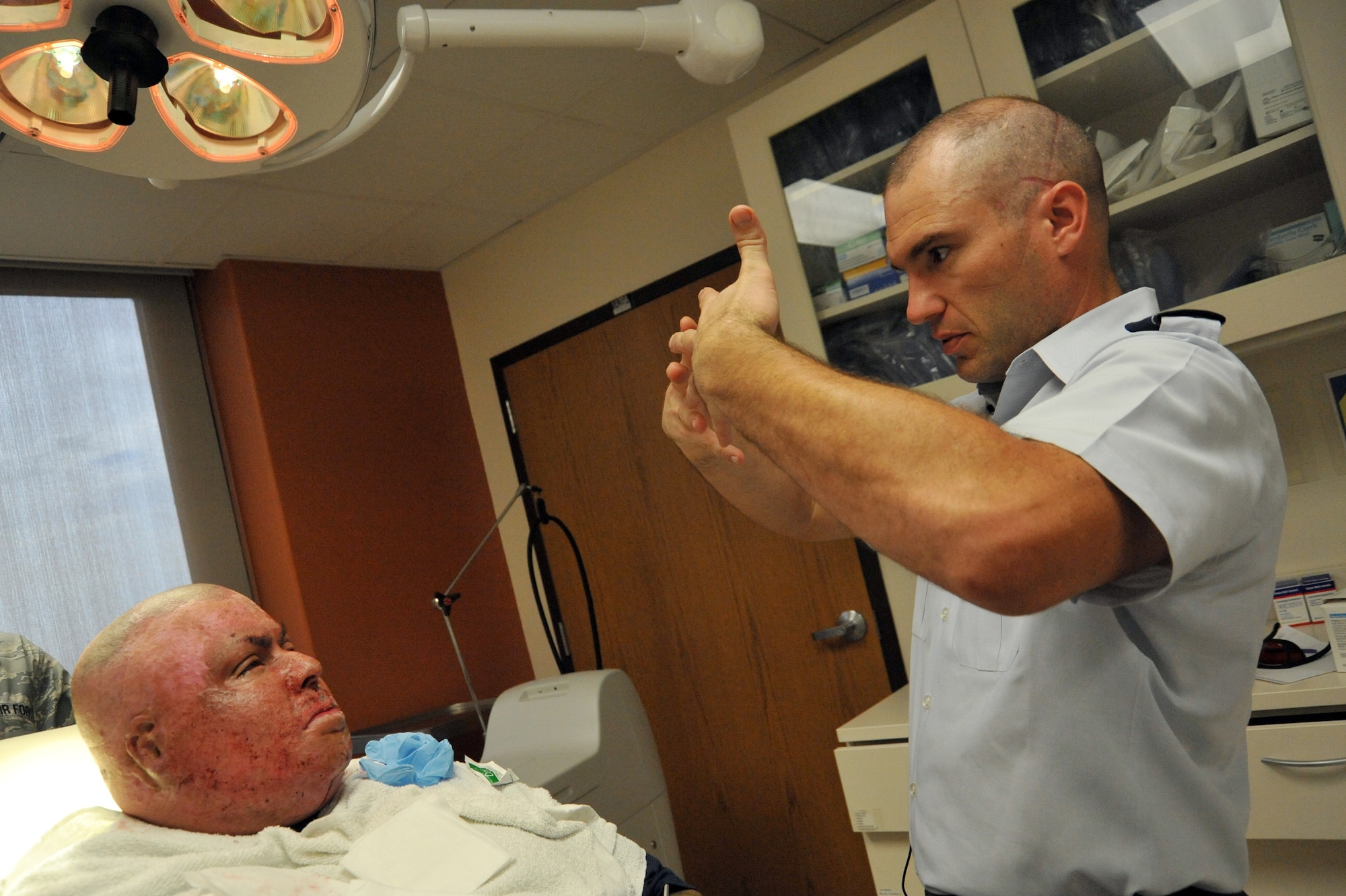 Lt. Col. Chad Hivnor explains the effects of the new fractional laser to treat battle scars to Gabriel Alvarado during a medical appointment at Wilford Hall Ambulatory Surgical Center, San Antonio, Texas, July 9, 2012. This technology gives wounded warriors the opportunity to gain a better range of motion. (U.S. Air Force photo/Desiree N. Palacios)