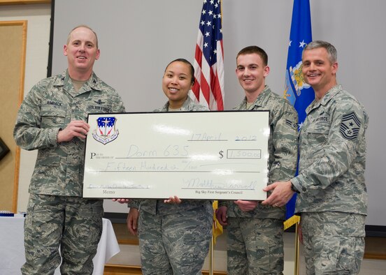 Chief Master Sgt. Charles Anderson, 341st Missile Wing command chief, far right, and Col. Edward Rimback, 341st Operations Group commander, far left, present two Dorm 635 residents with a $1,500 check for the winning the Dorm of the Quarter award.  Anderson has served in several different positions during his Air Force career, and has traveled a good portion of the world.  (U.S. Air Force photo/Beau Wade)