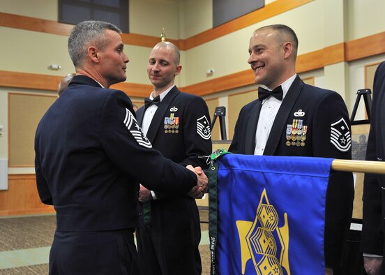 Anderson coins new first sergeants during a first sergeants induction ceremony in March.  After 27 years in the Air Force, Anderson plans to retire and settle down in a small town with his family.  (U.S. Air Force photo/John Turner)